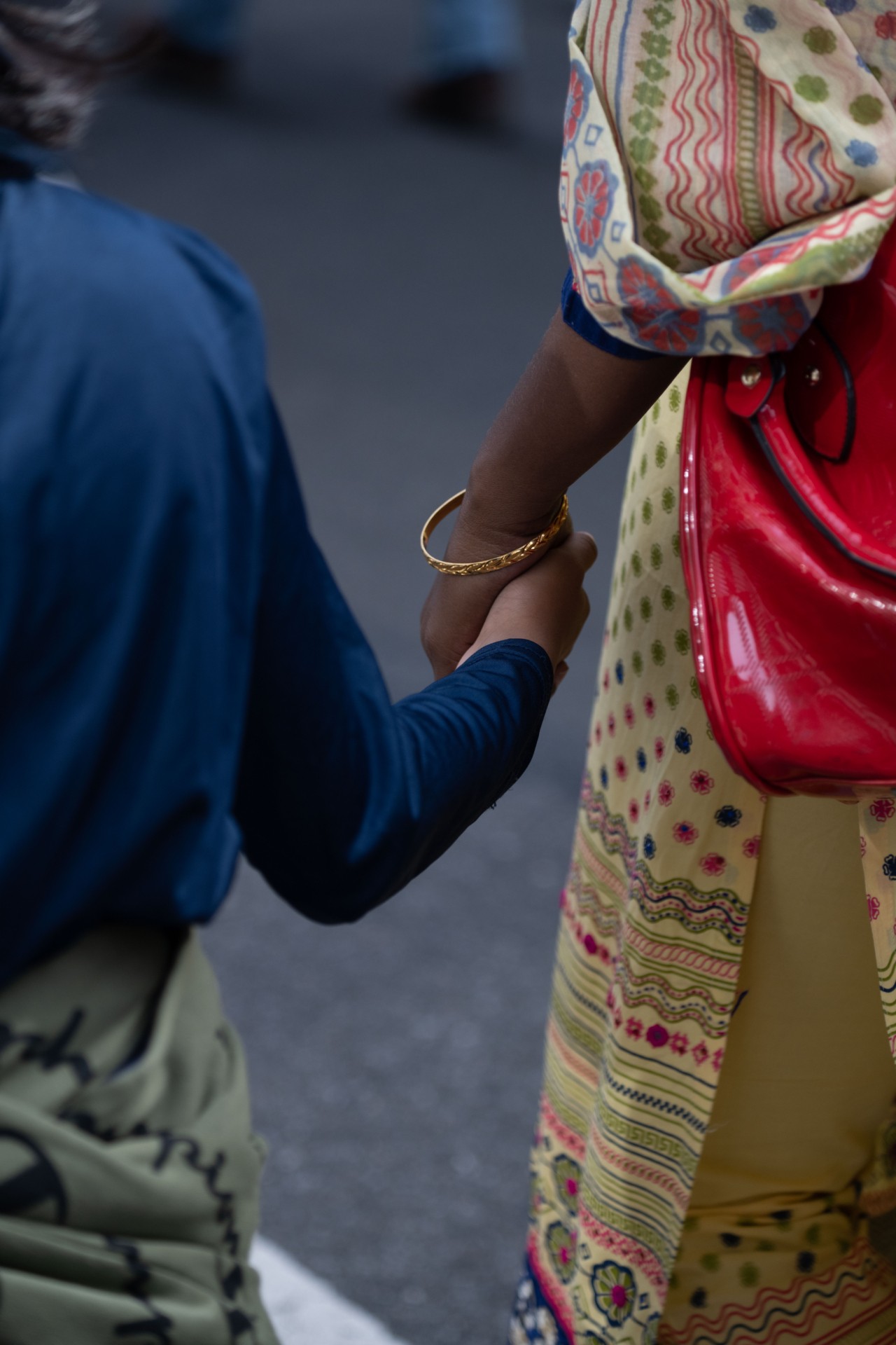 An adult and a child hold hands at climate change protests in NYC.