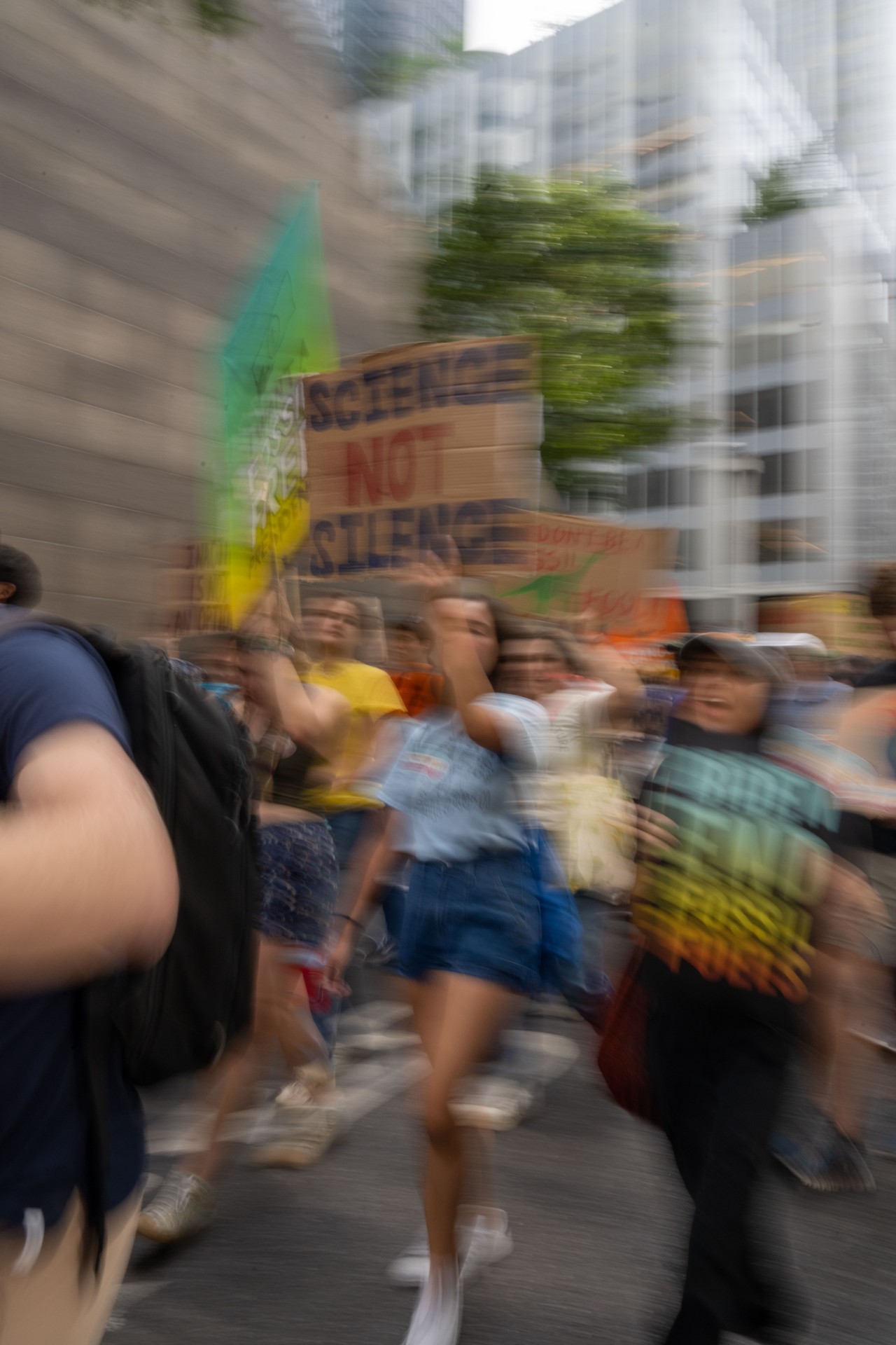 A blurry shot of climate activists and protesters holding signs while walking the streets of NYC.