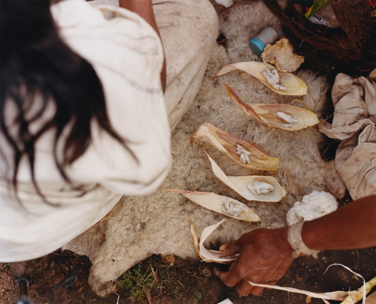 Kogi people surrounding Indigenous artifacts on a beach in Colombia.