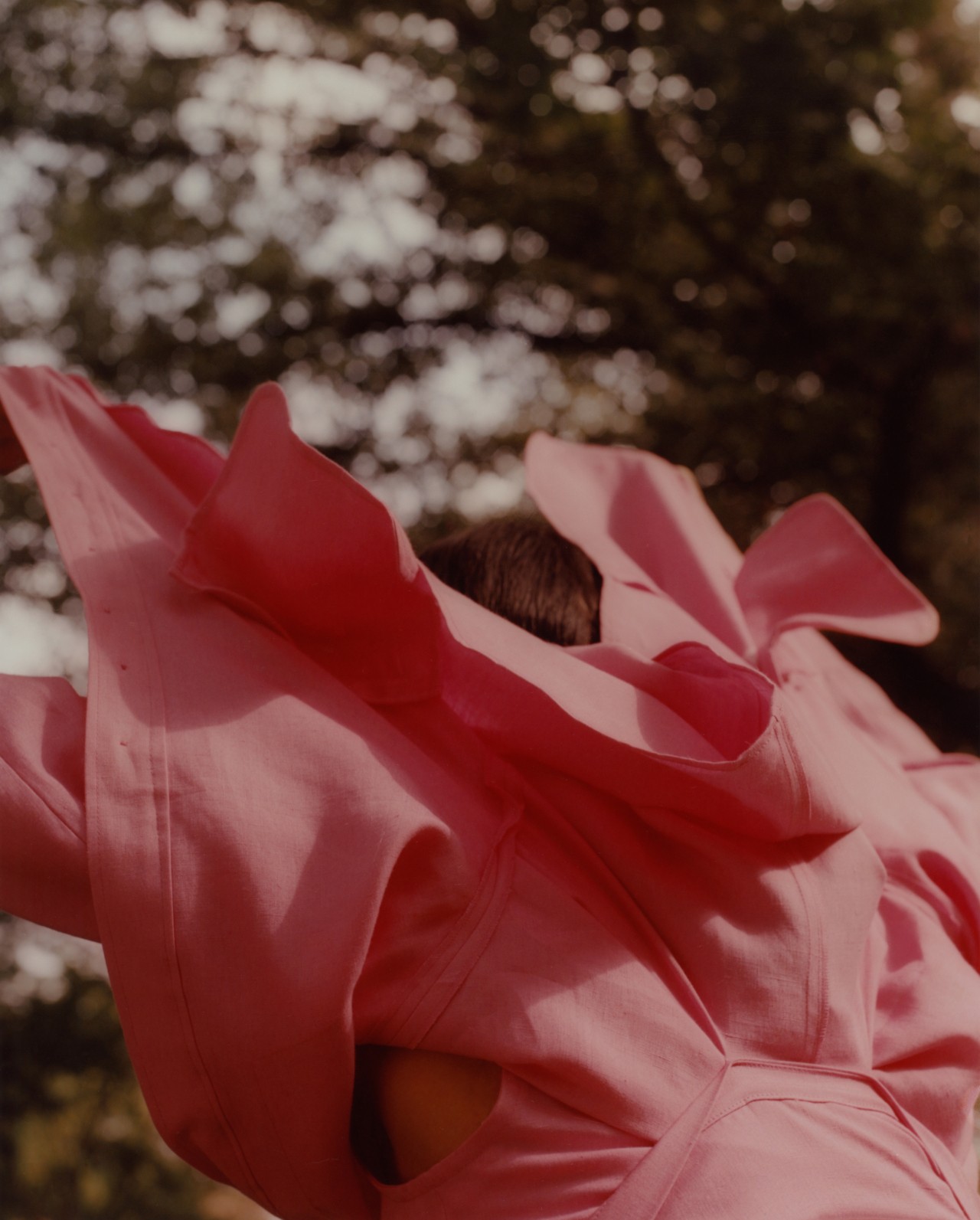 Someone wearing a pink linen fabric top faces away from the camera.