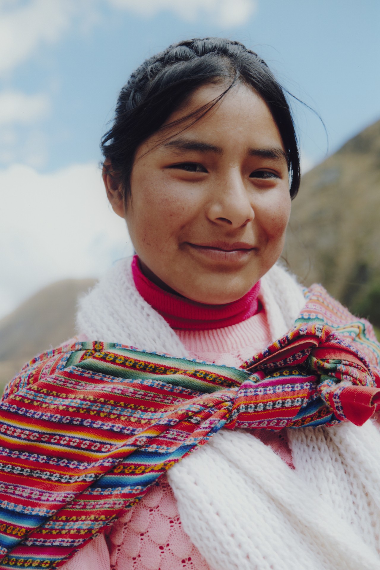 A young woman looks at the camera and smiles in Cusco, Peru