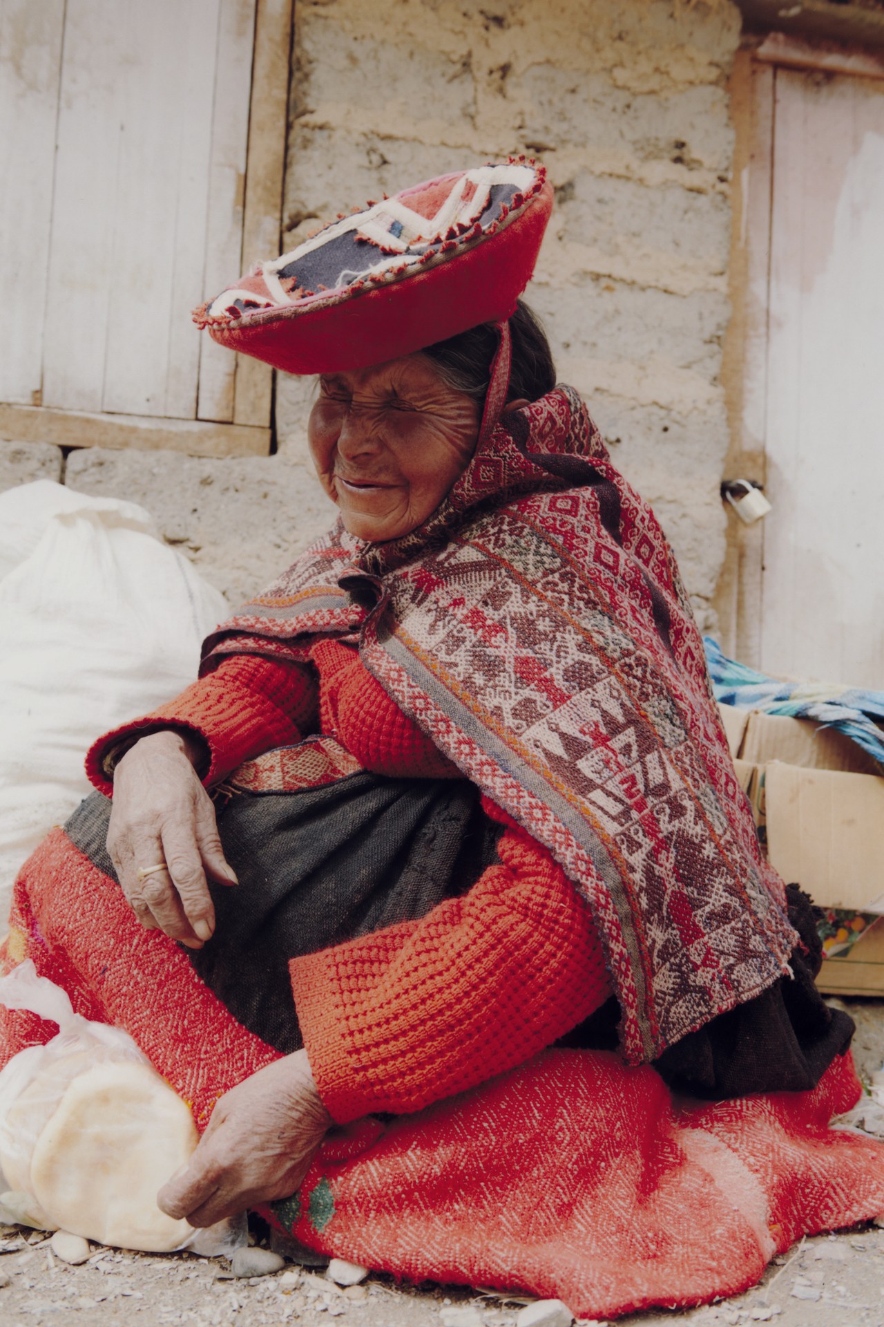 An older woman from the Chincheros community sits on the ground