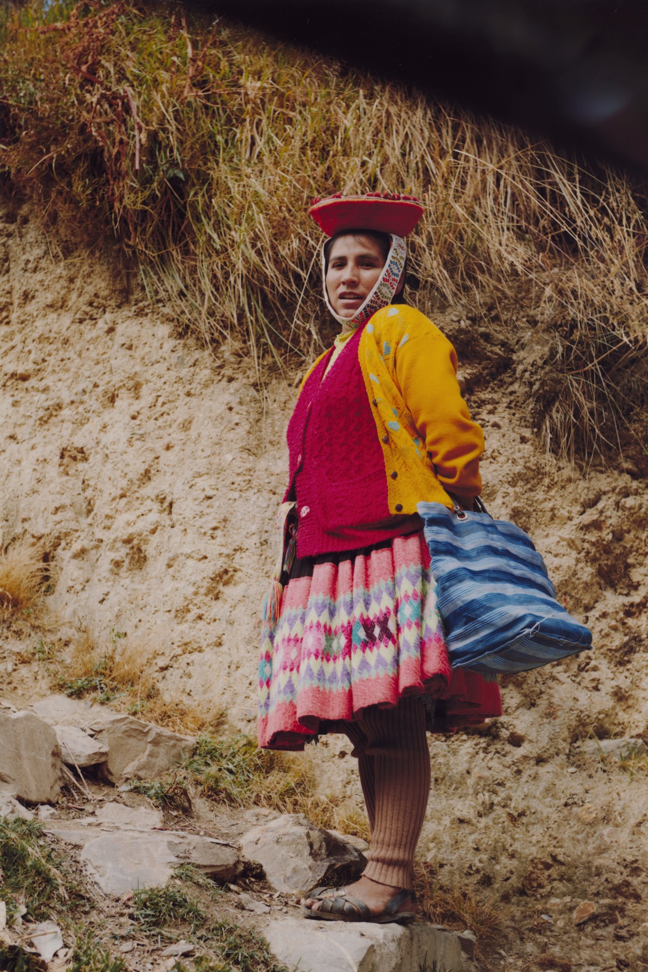 A woman poses on rocky terrain in Peru