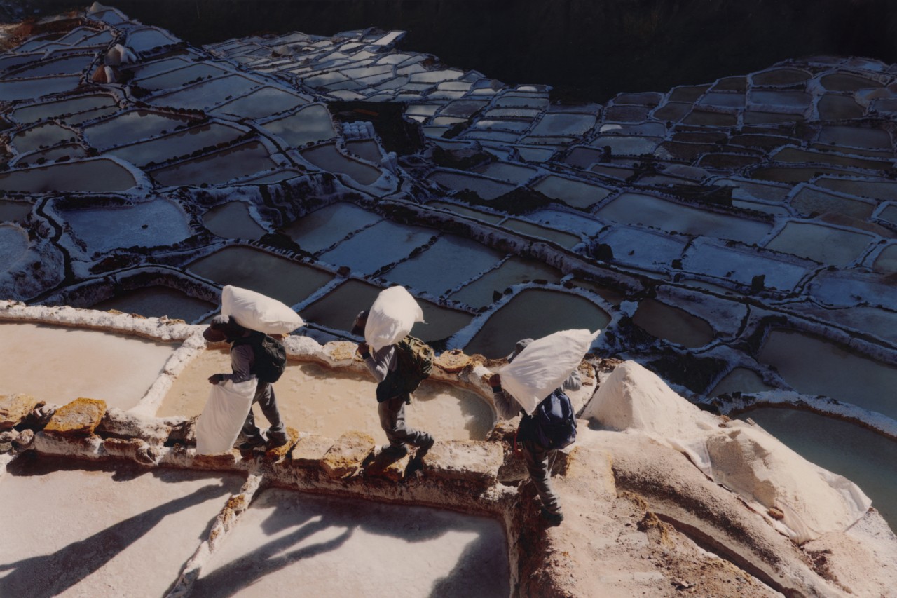 Workers carrying bags of salt in the Maras salt mines