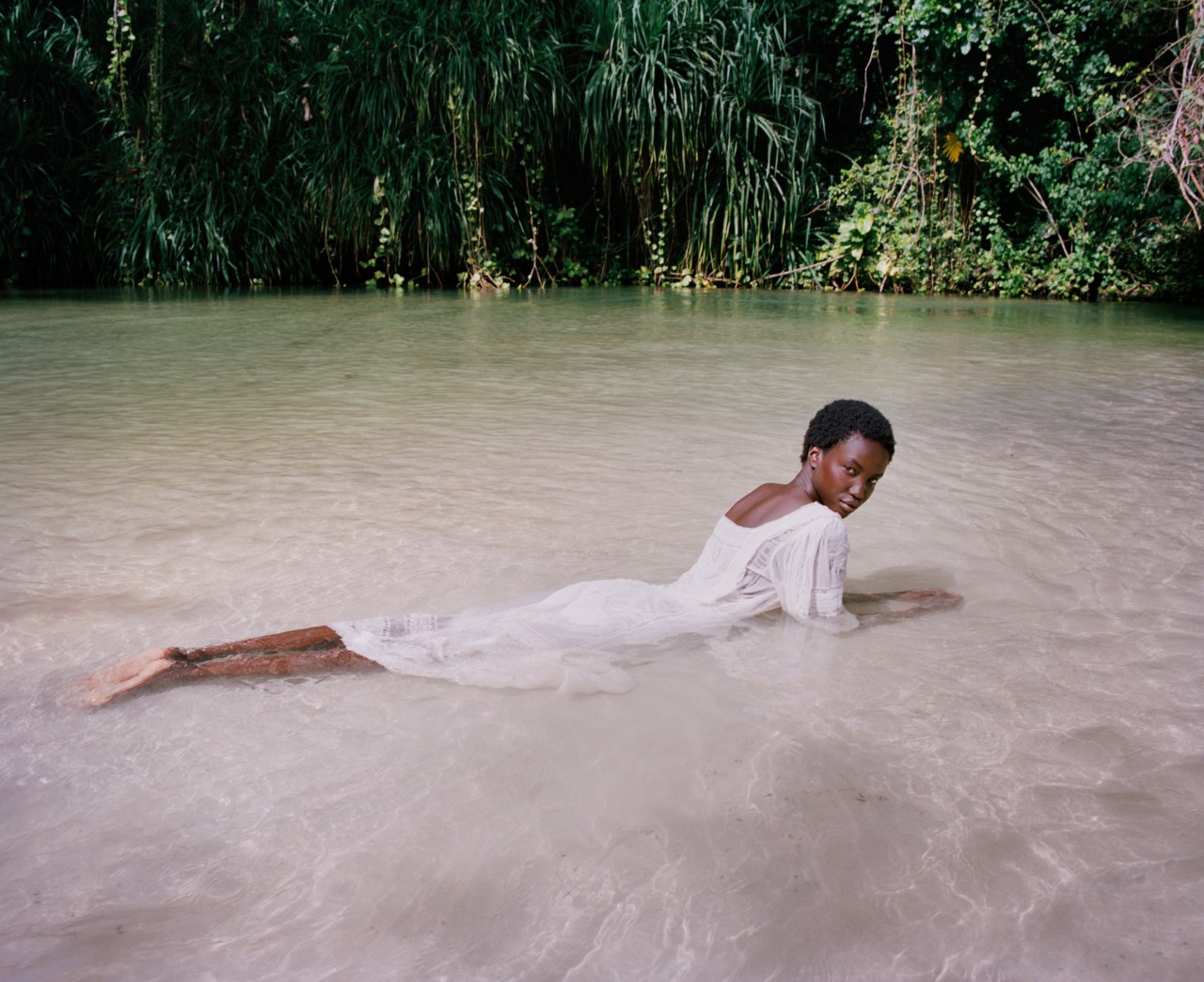 Woman lying in water, photographed by Nadine Ijewere.
