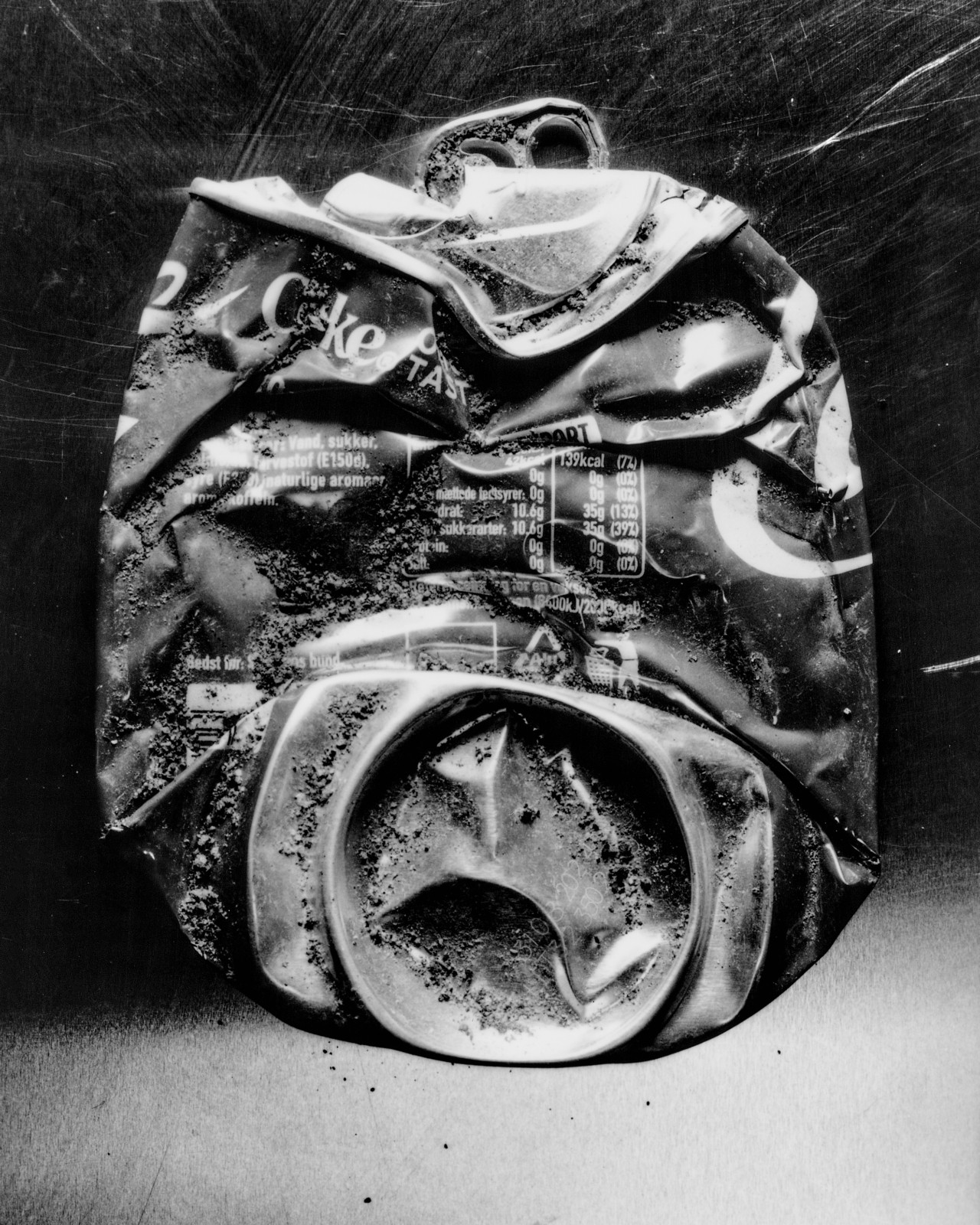 Crushed can of Coca-Cola photographed in black and white