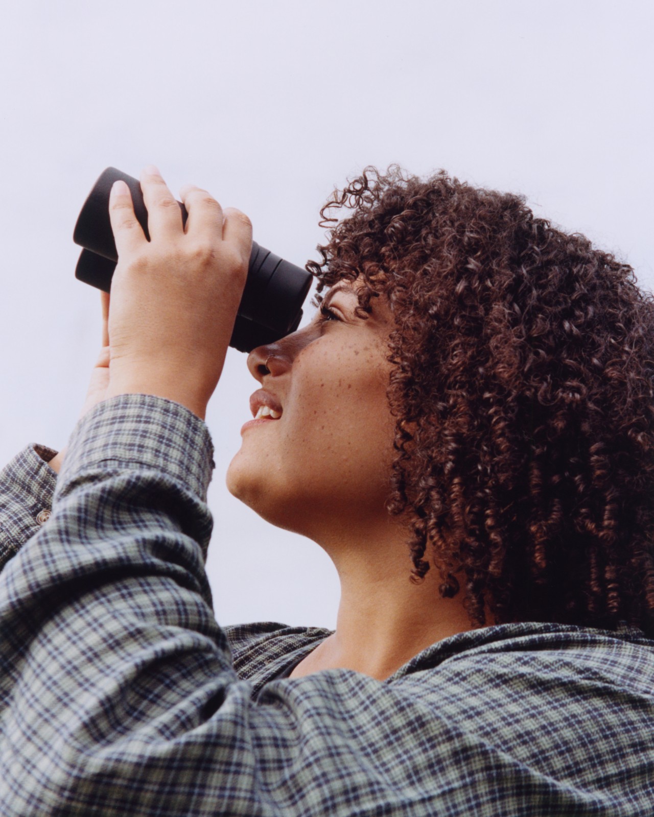 Elie looks up at the sky through her binoculars.