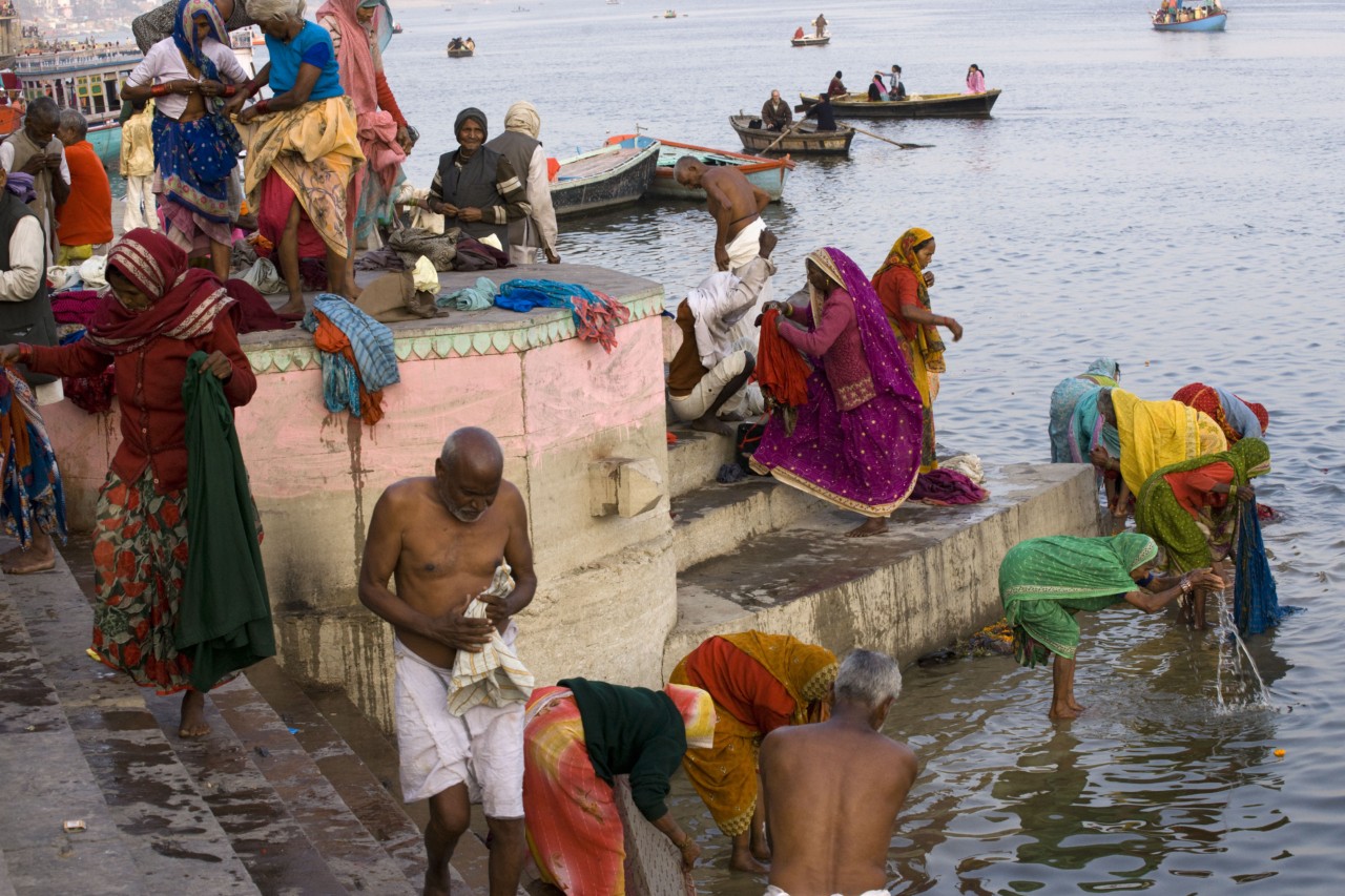 INDIA. 1. Uttar Pradesh. Varanasi. After a sacred bath, Hindu pilgrims wash their clothes in the river Ganges.