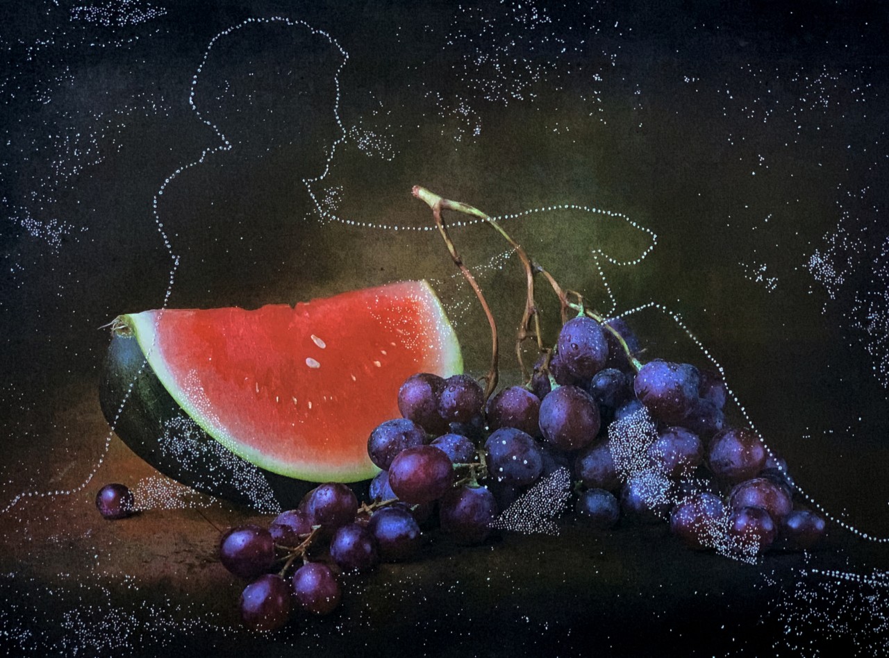 The outline of a person sits down next to a bunch of grapes and a slice of watermelon.