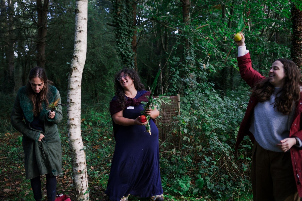 Three people smiling and laugh in the middle of a forest.