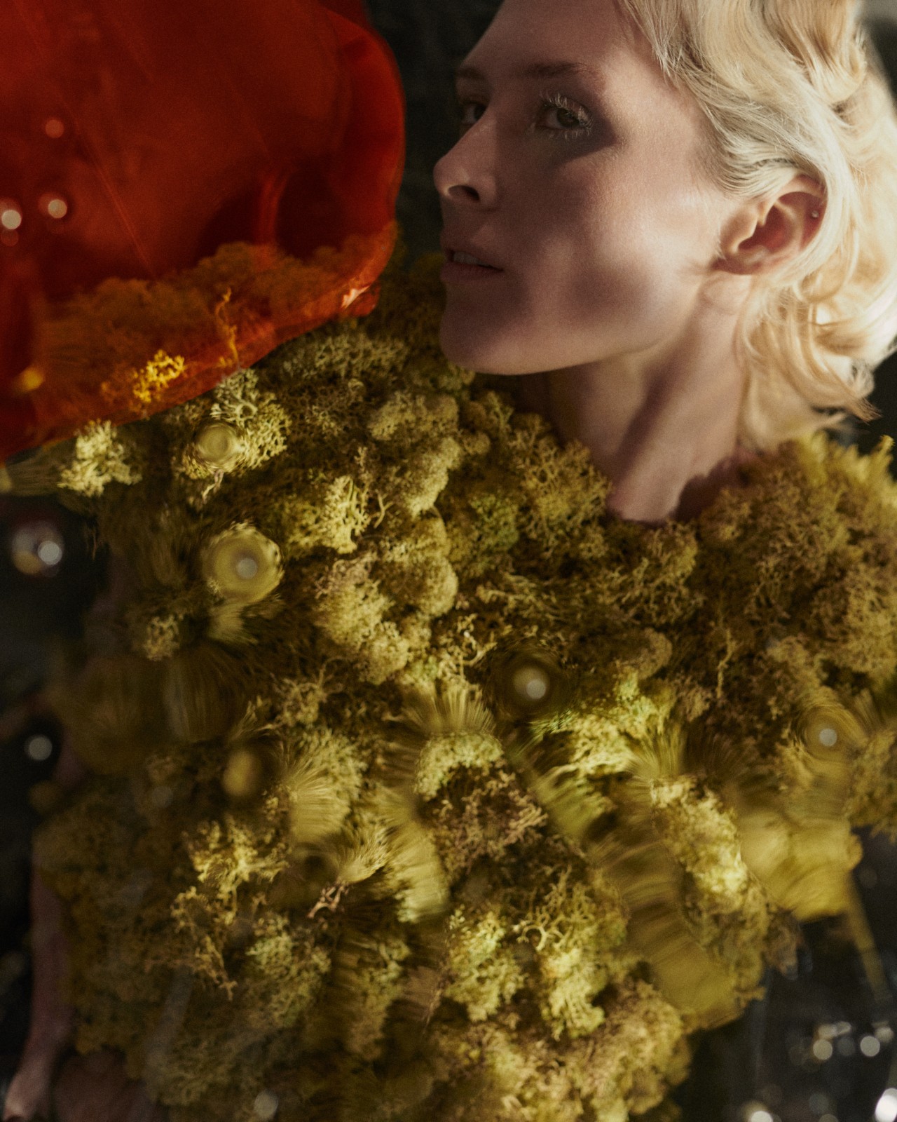 A model lays down posing while wearing bright green biocouture.