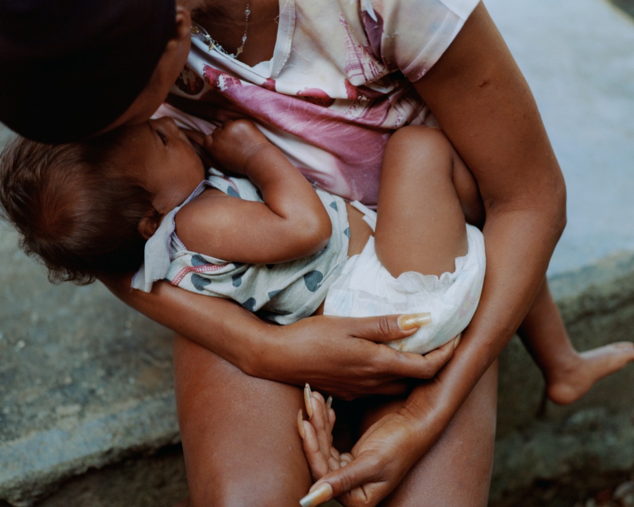 An older woman holds a baby in her arms.