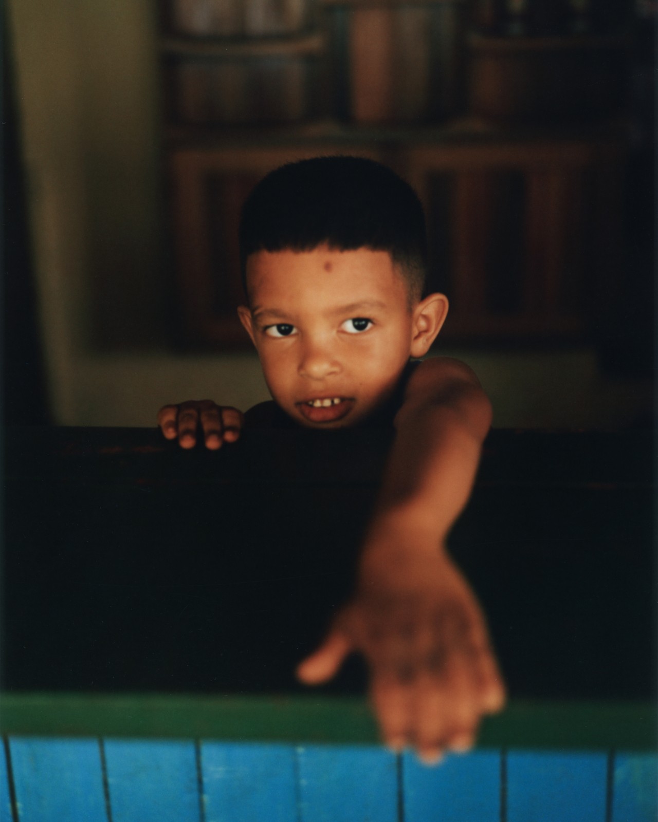 A young child reaches their hand over a counter top.