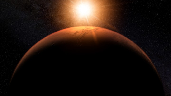 The sun shines right above the surface of Mars.