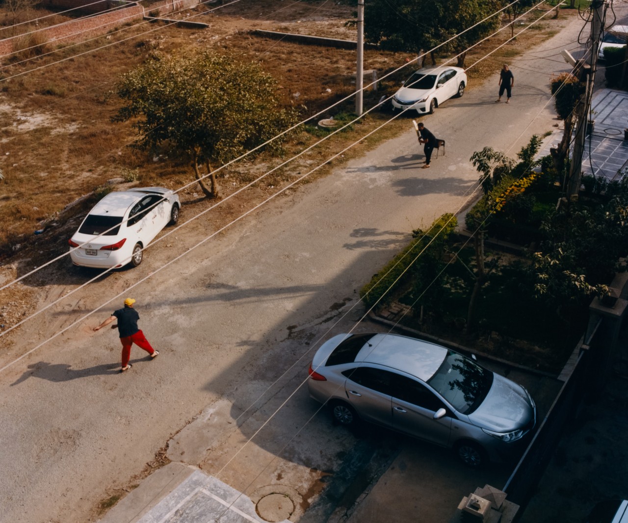 Two people play a game in the street.