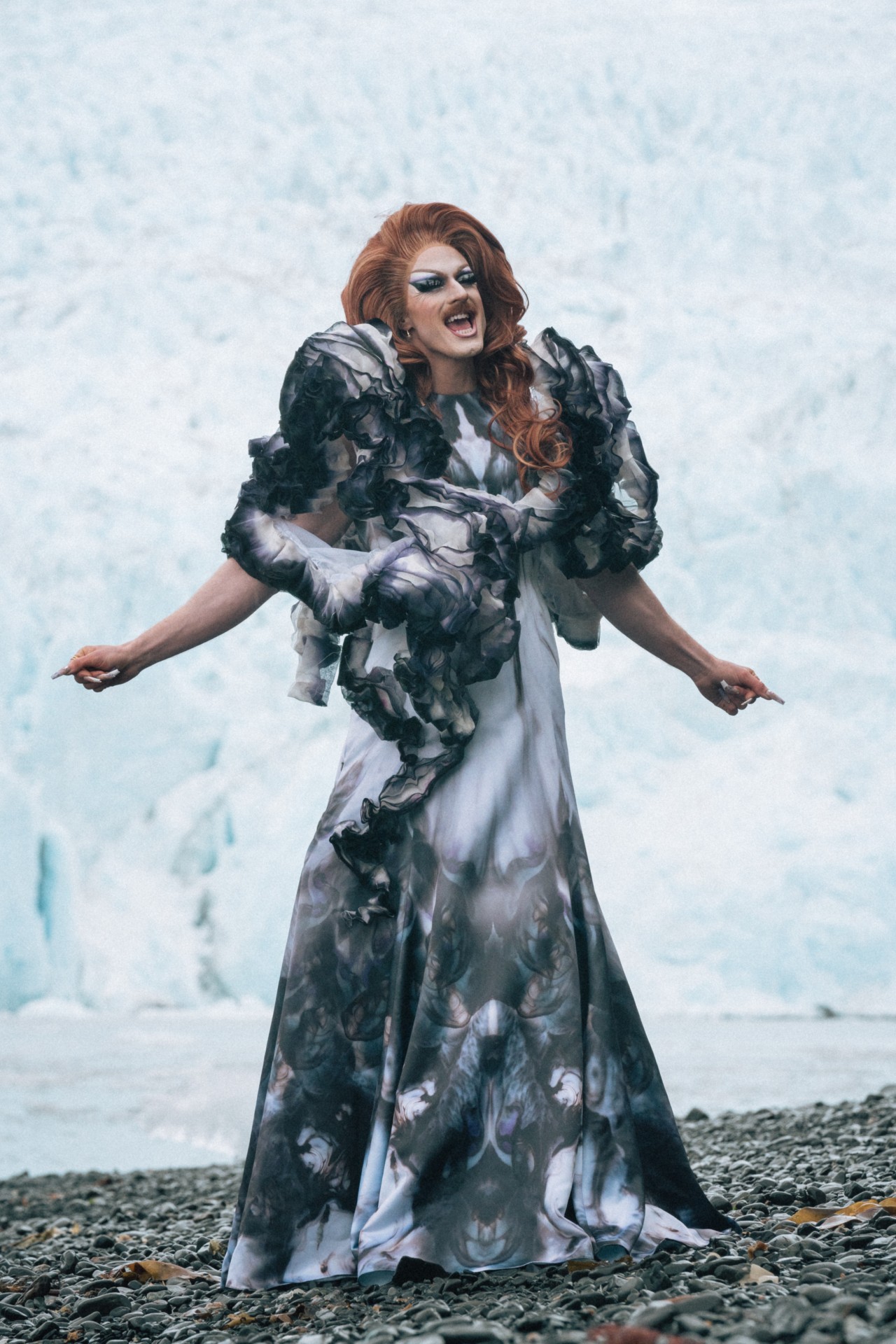 Pattie Gonia sings in front of an icy back drop.