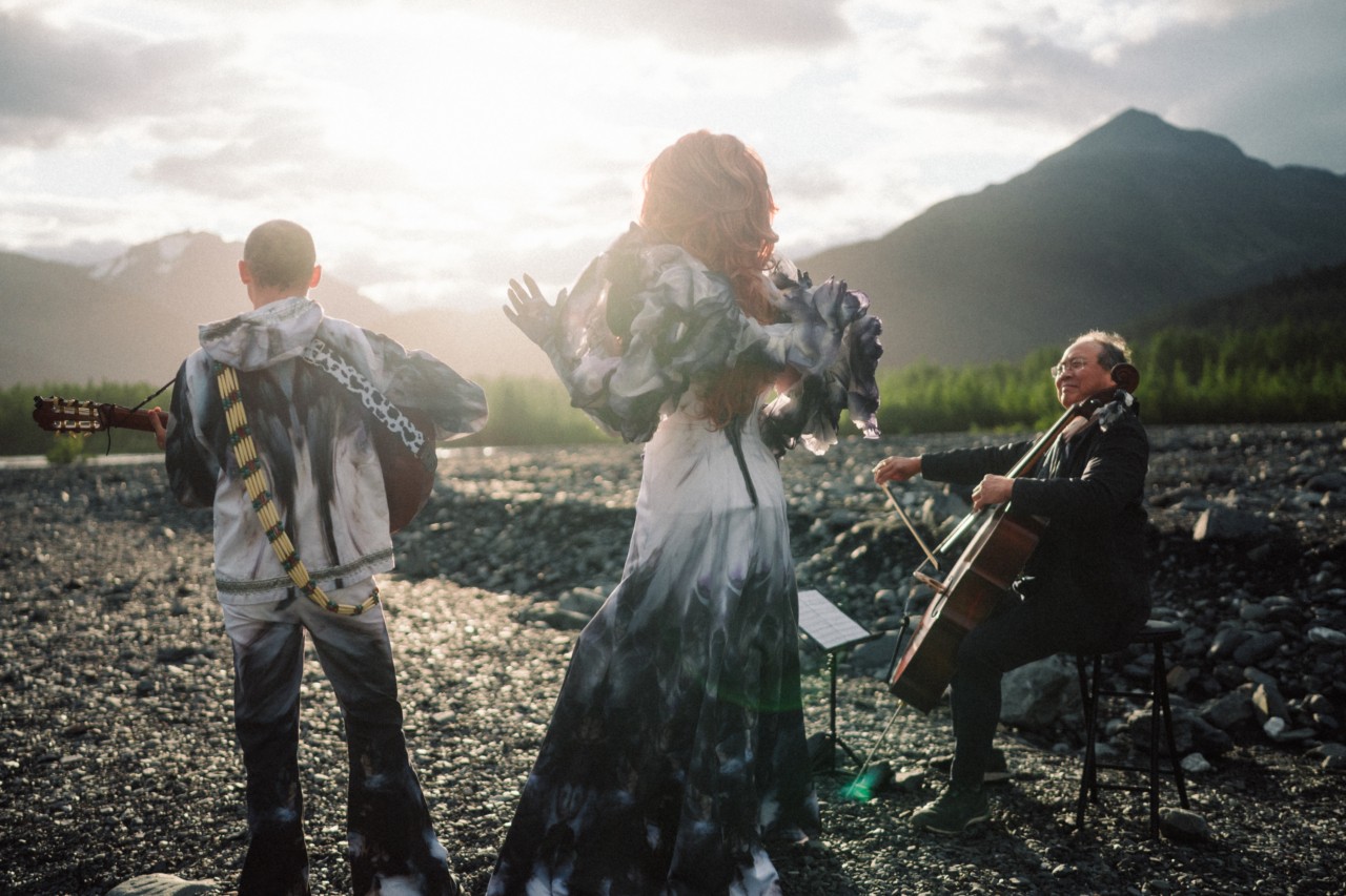 Pattie Gonia, Yo Yo Ma, and Quinn Christopherson perform with their backs facing the camera.
