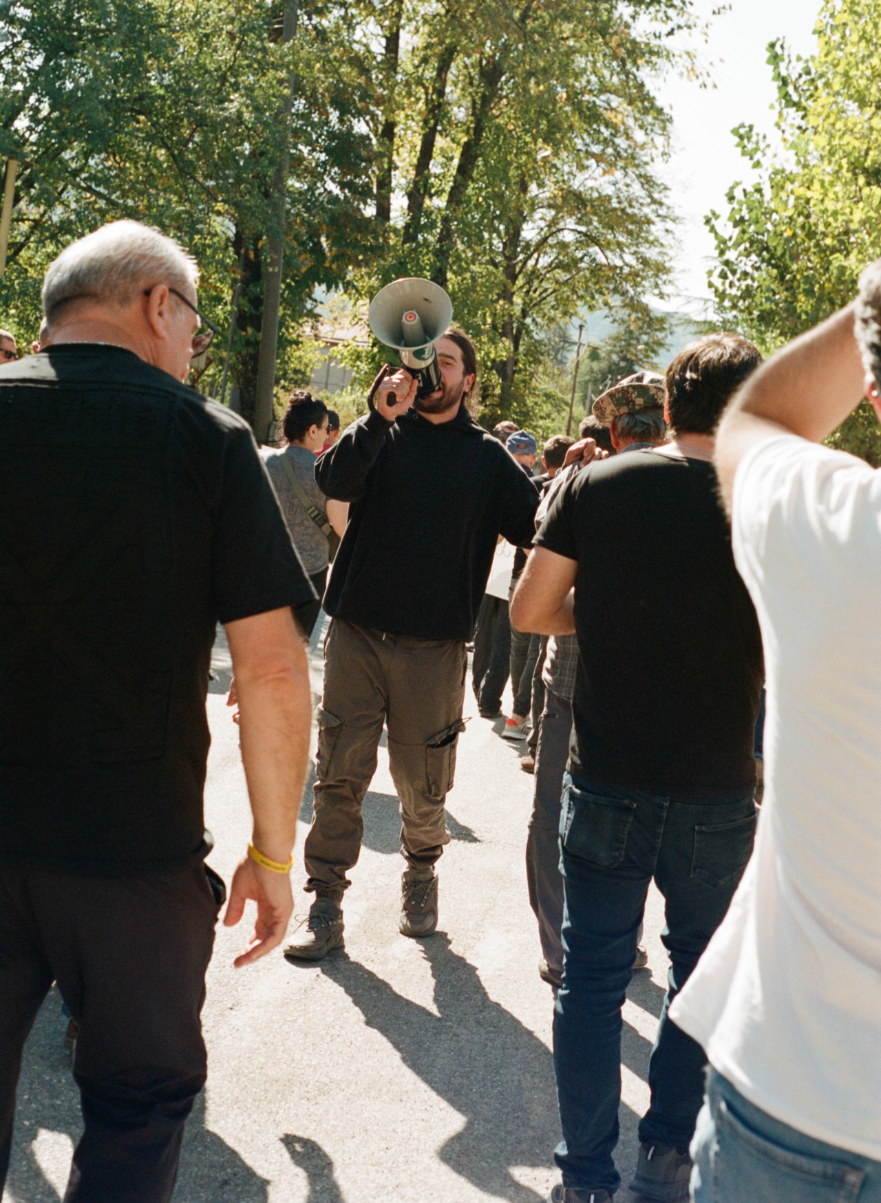 A person speaks into a megaphone while several people surround them.