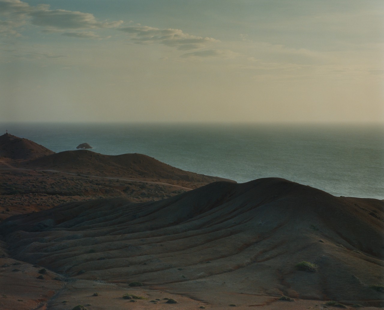 Small mountain dunes frame the distant ocean.