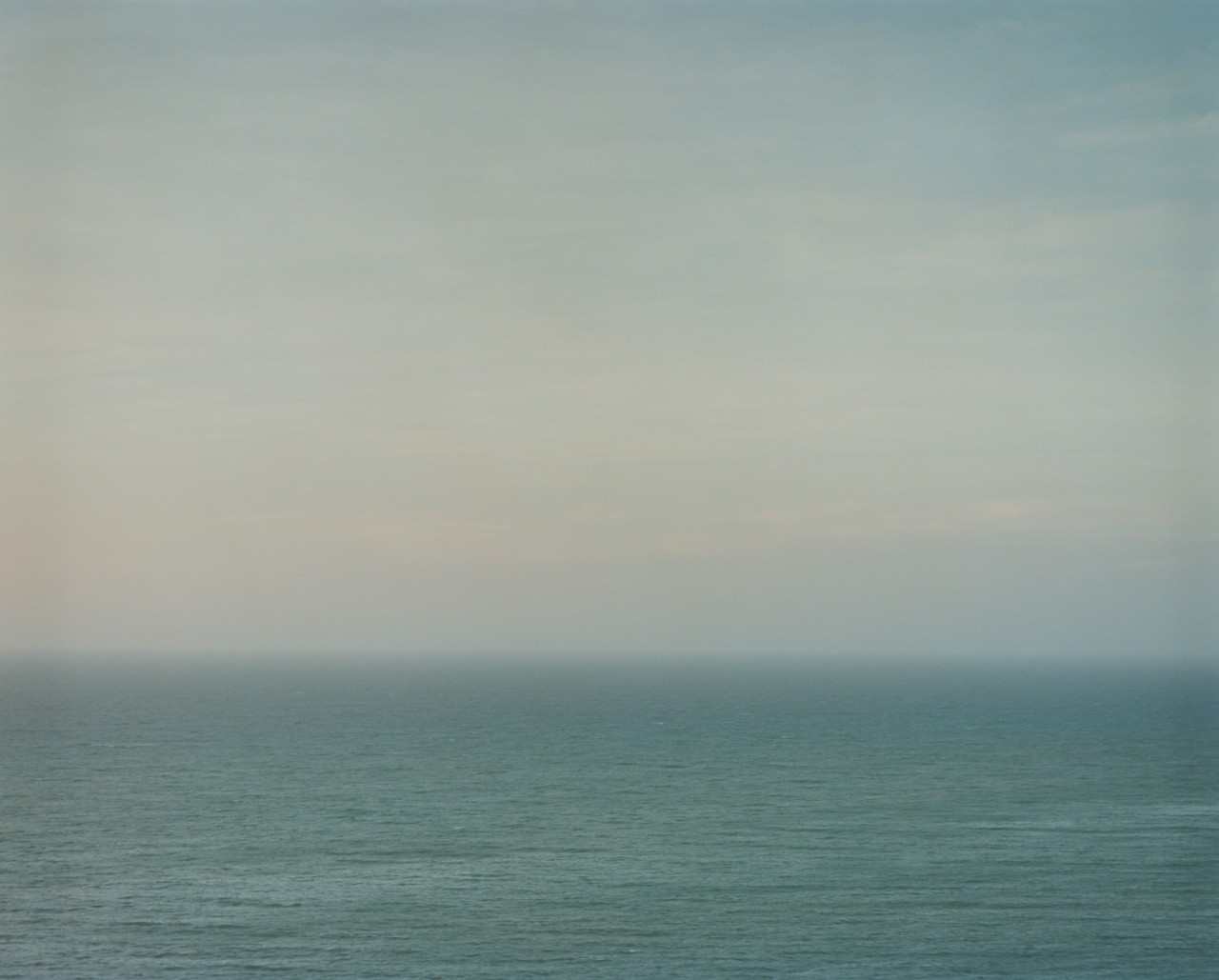 A cloudy sky sits above the vast ocean.