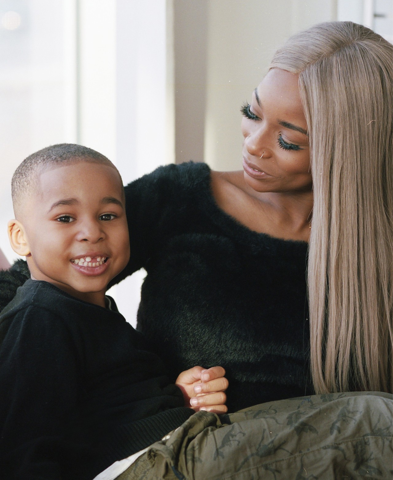 A young mother looks down at her son as he smiles.