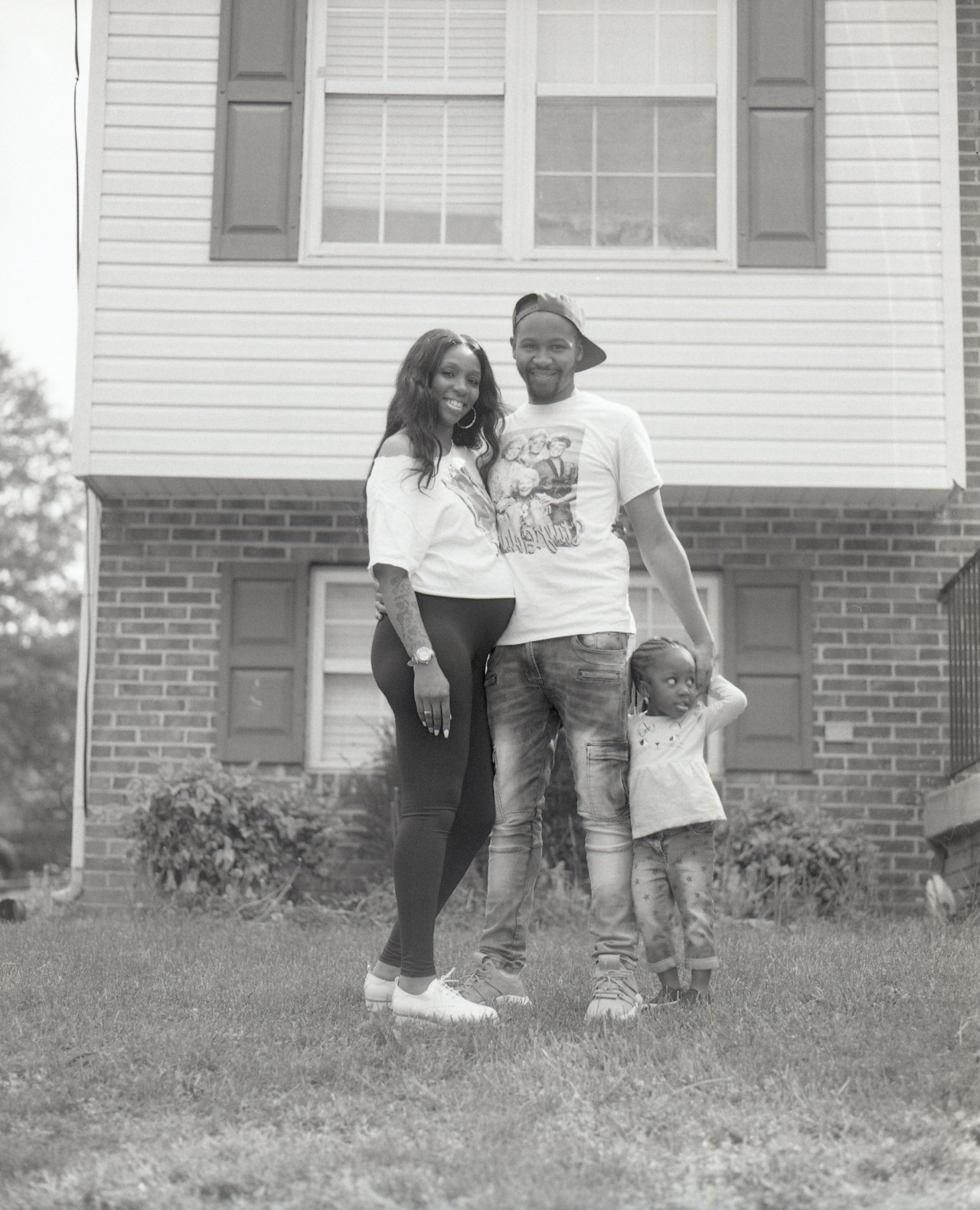 A young couple poses with heir child on the front lawn of a Washington, D.C home.