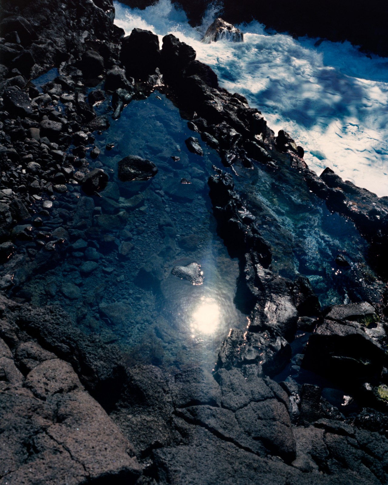 The side of blue and black cliff.