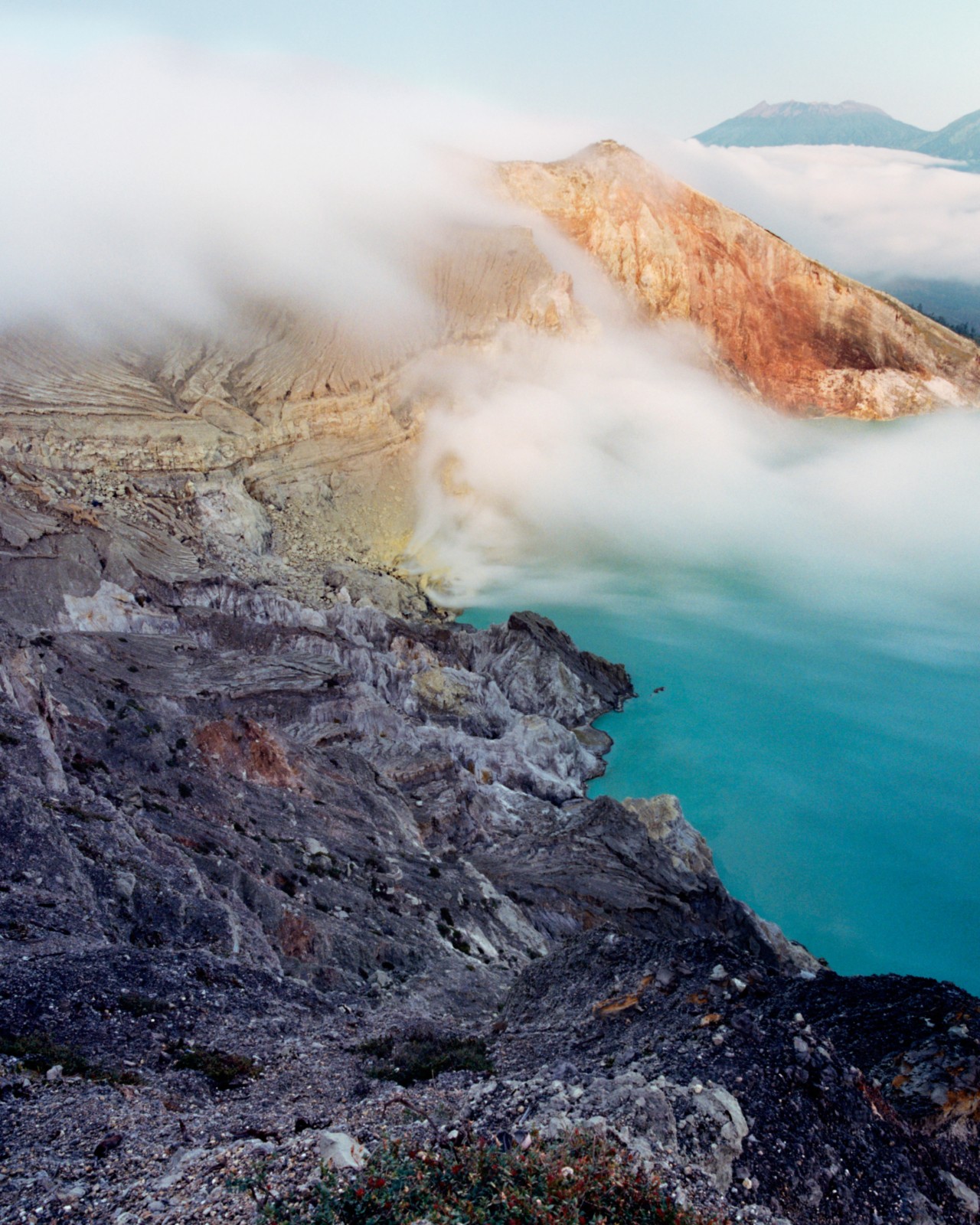 Light fog gathers above a seaside cliff.