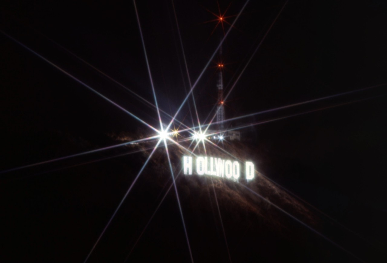 The Hollywood sign shines brightly in the night time.