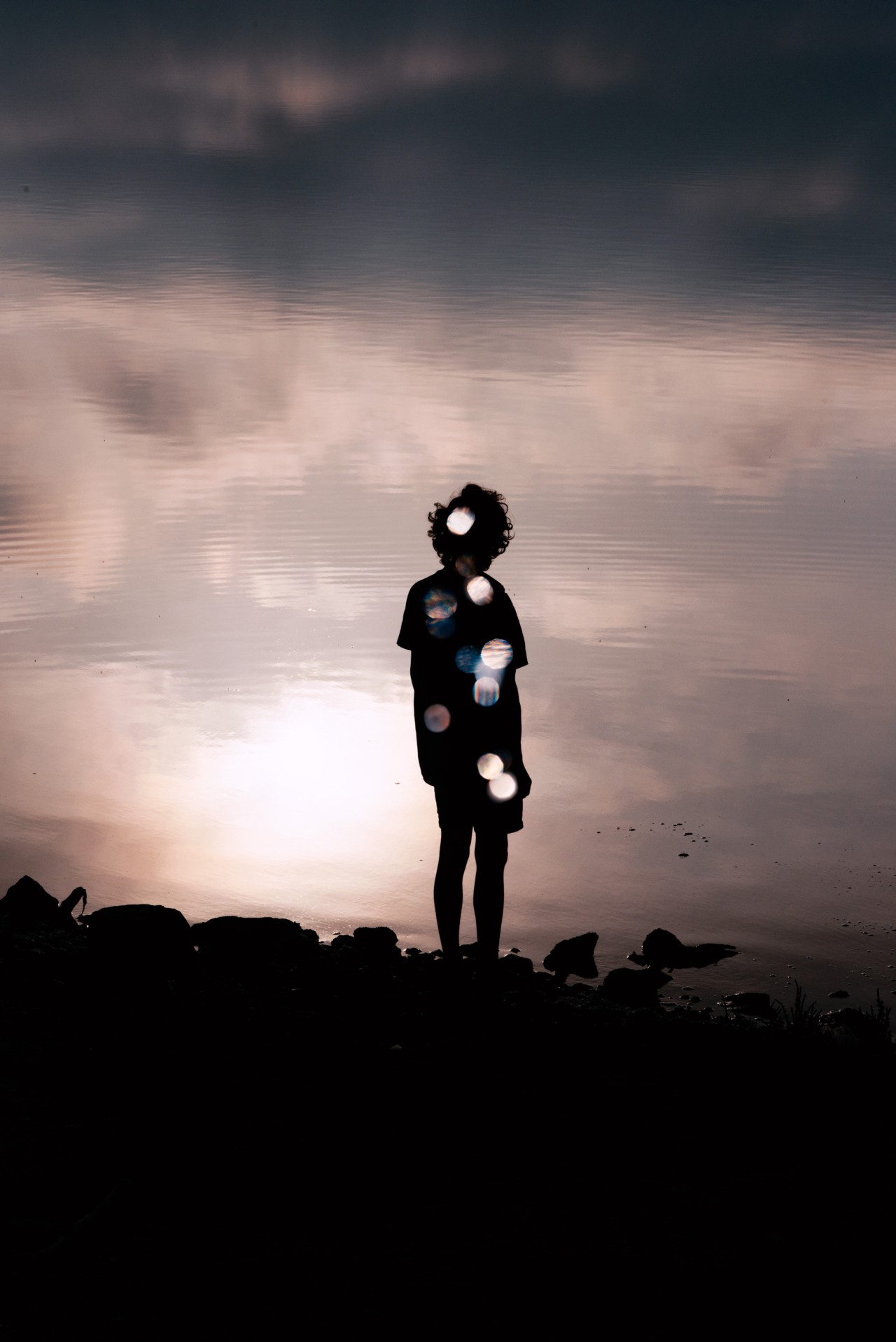The shadow of a human reflection is clear on the water's surface.