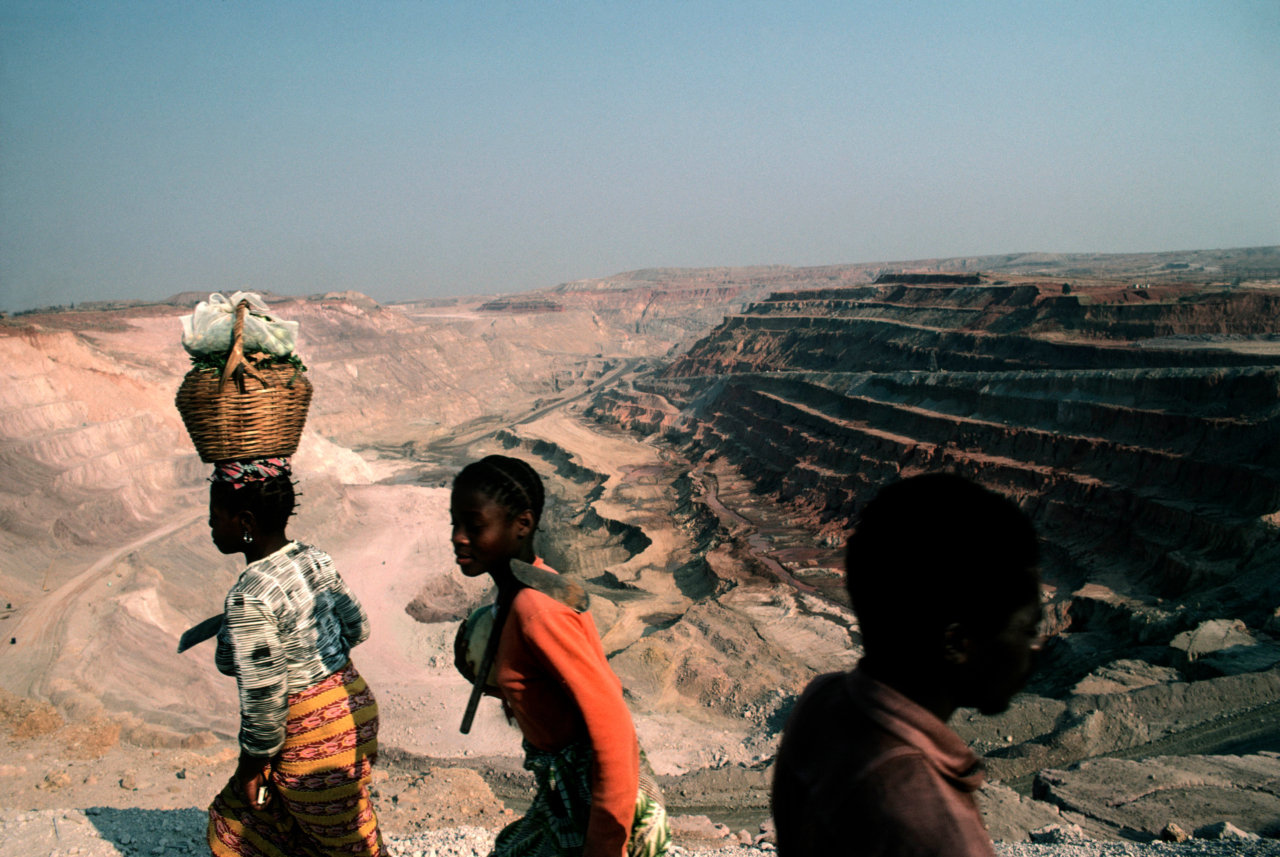 Three children walk along a dry basin in the Democratic Republic of Congo.