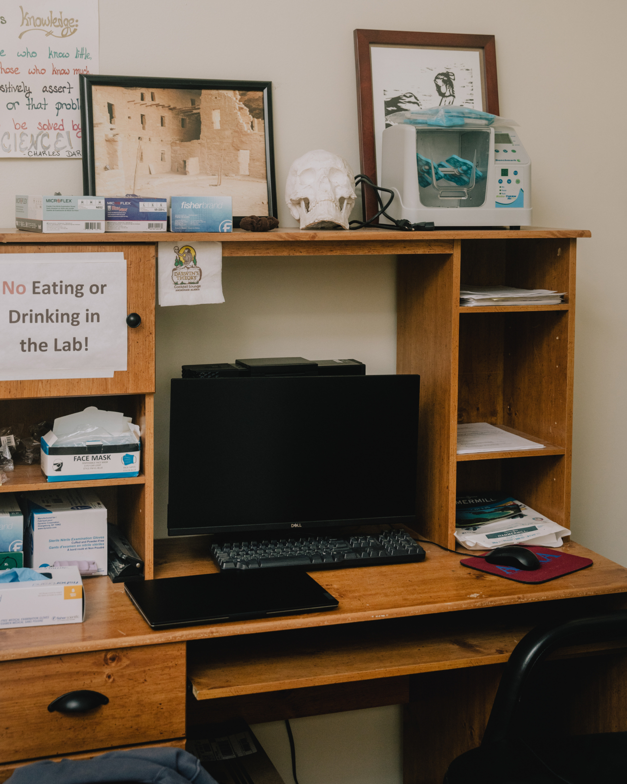 A desktop computer sits on the personal of a person working at a forensics lab.