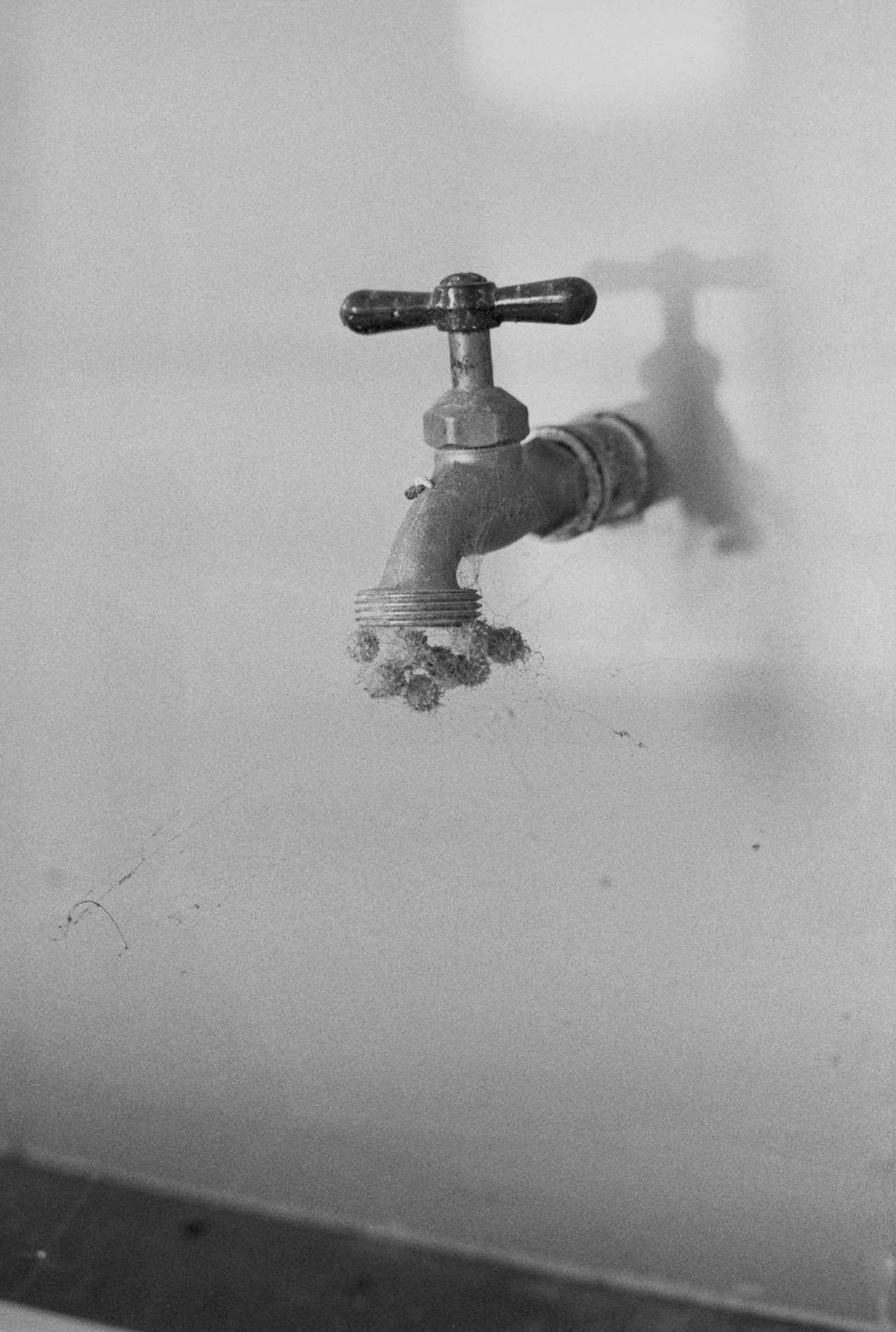 A metal water faucet is attached to a wall.