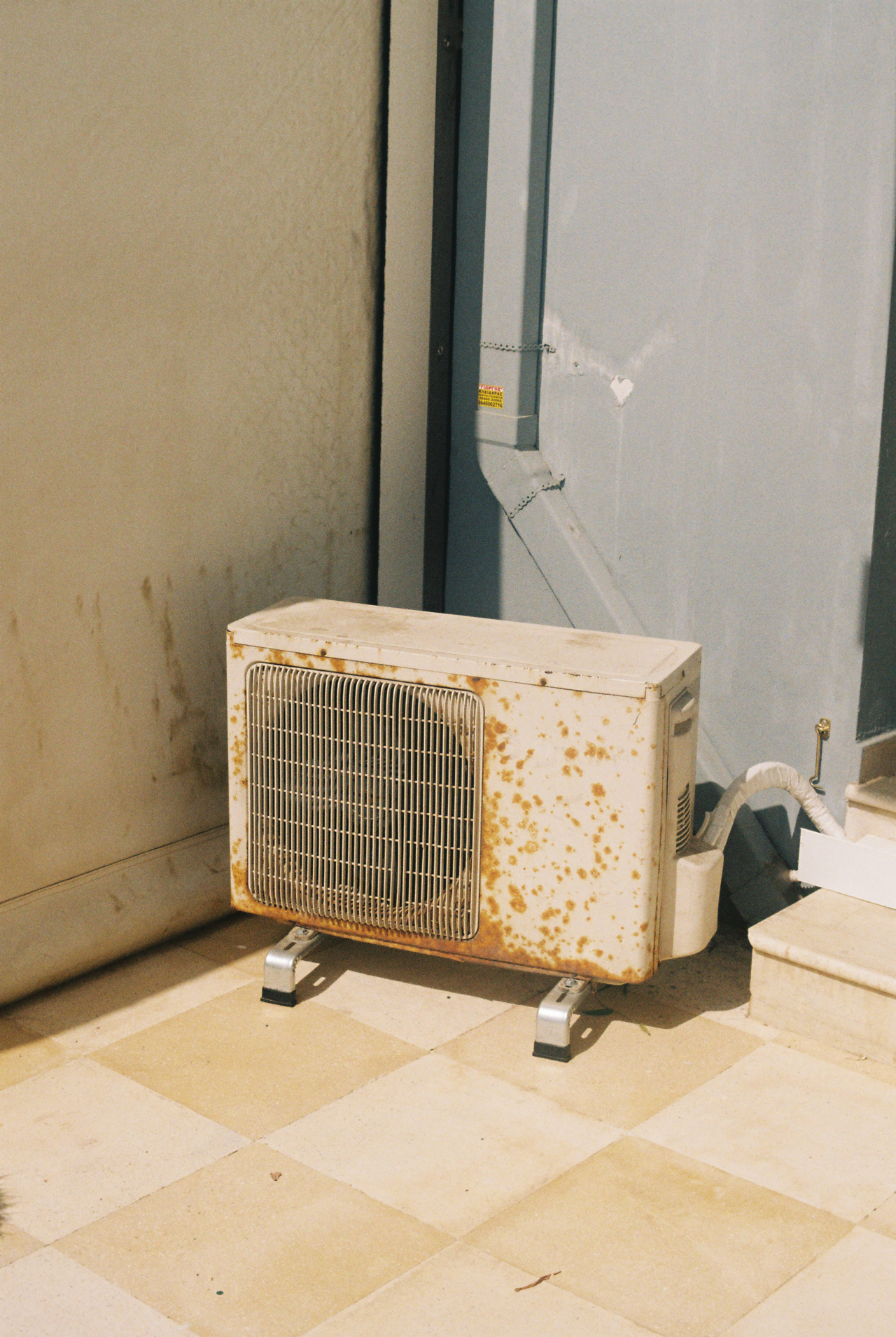 An old, heavily used AC unit sits in a corner.