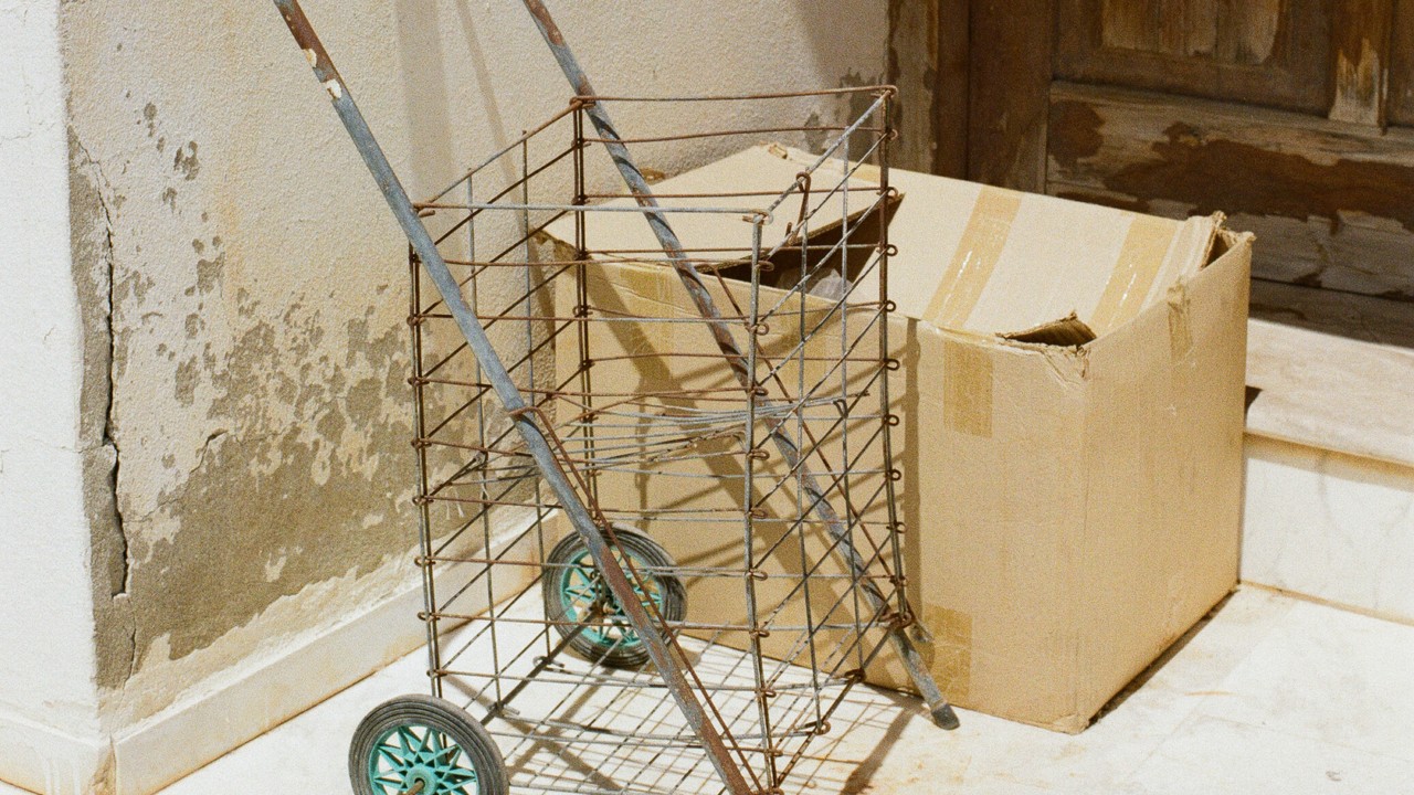 Abandoned shopping trolley next to a cardboard box.