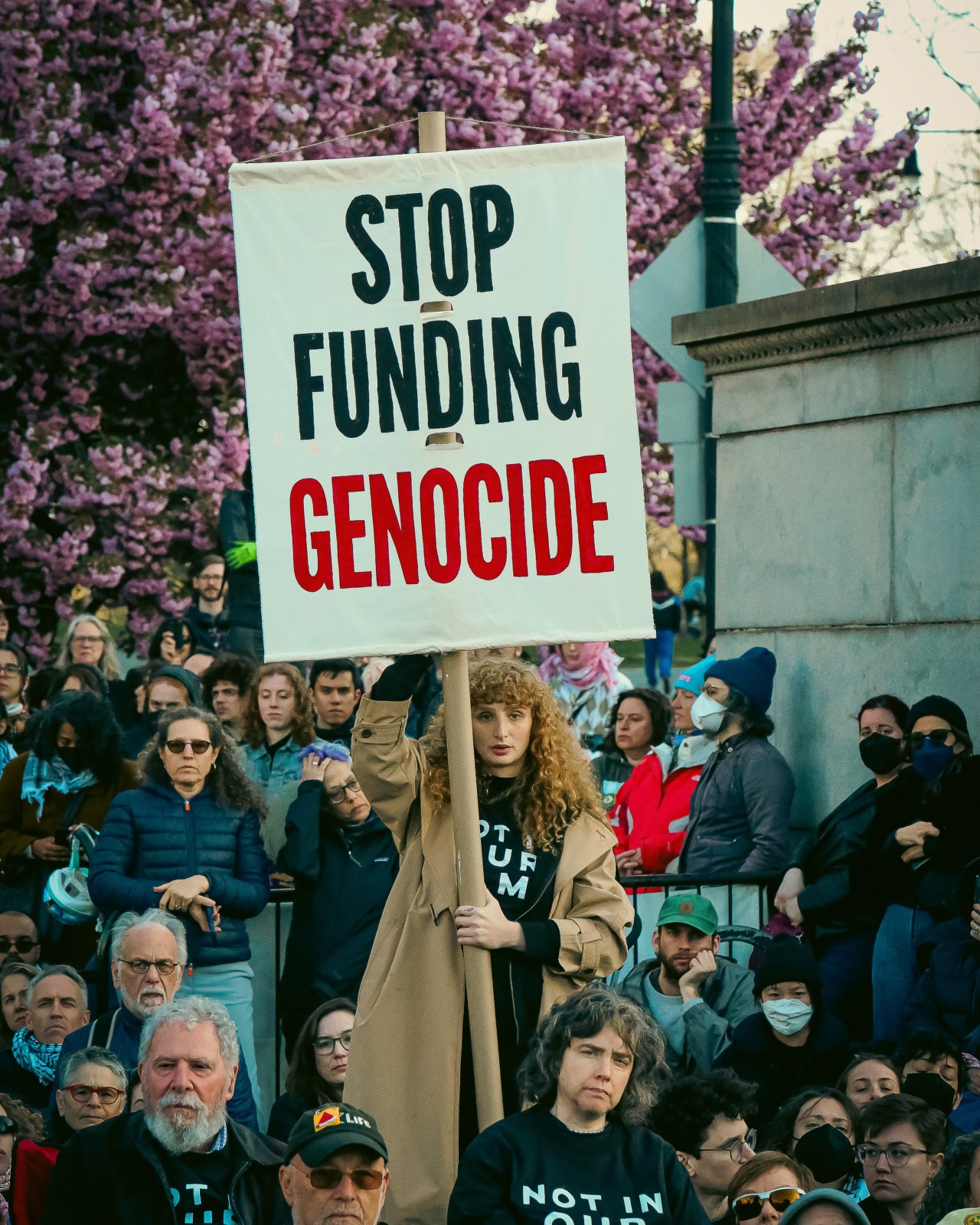 An activist holds up a sign at a protest that says 