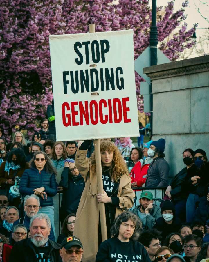 An activist holds up a sign at a protest that says 