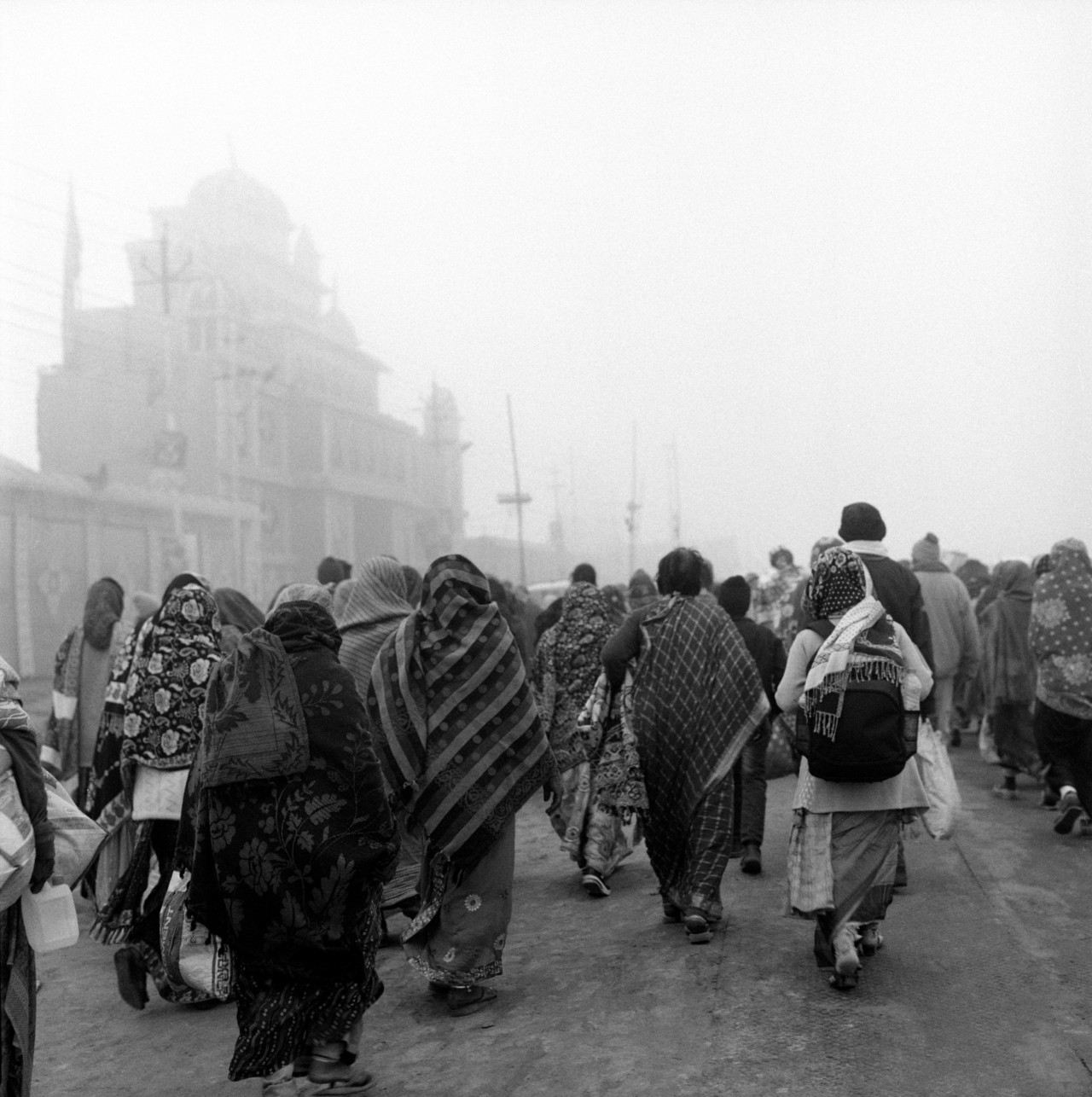 Pilgrims and tourists head to the Kumbh at dawn.