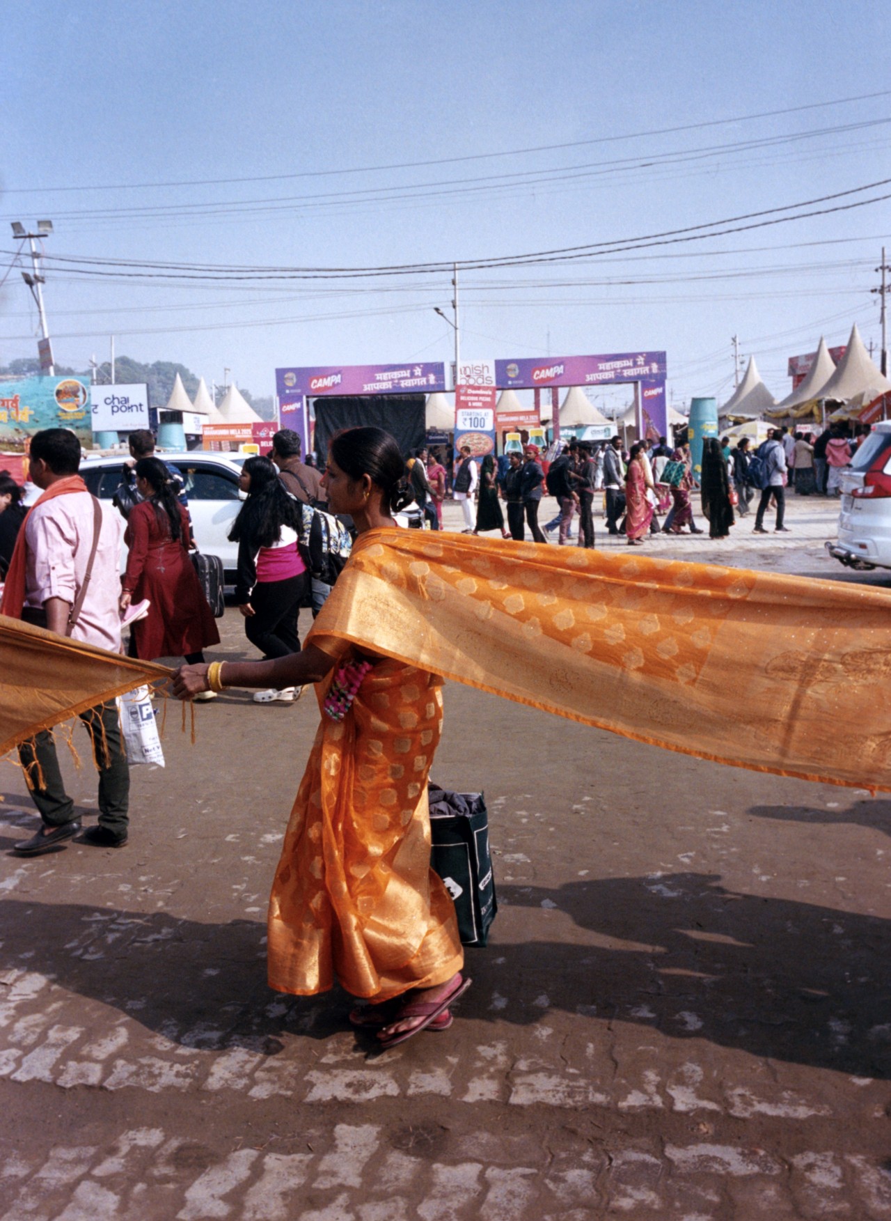 A woman holds onto another woman’s sari in order to avoid getting lost in the crowd.