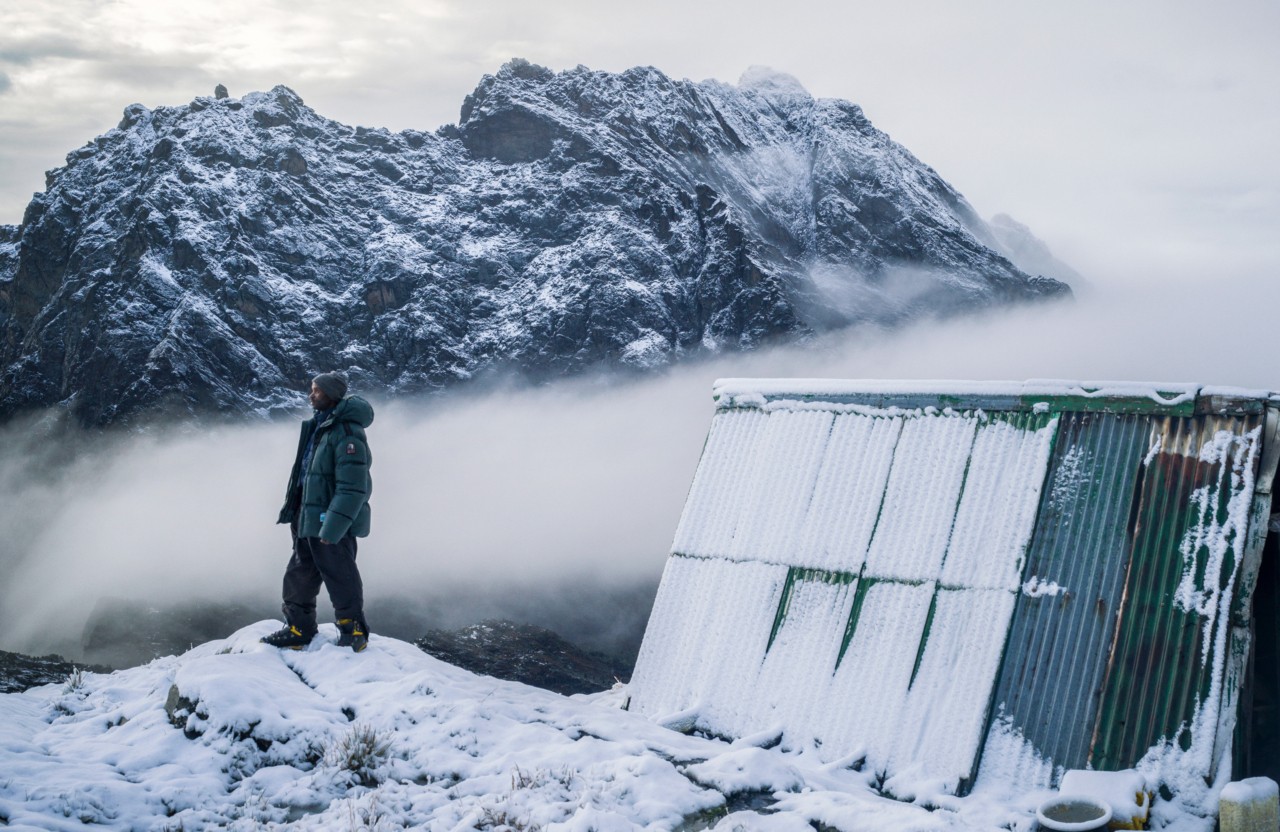 Person looking out at a mountain in snowy weather.
