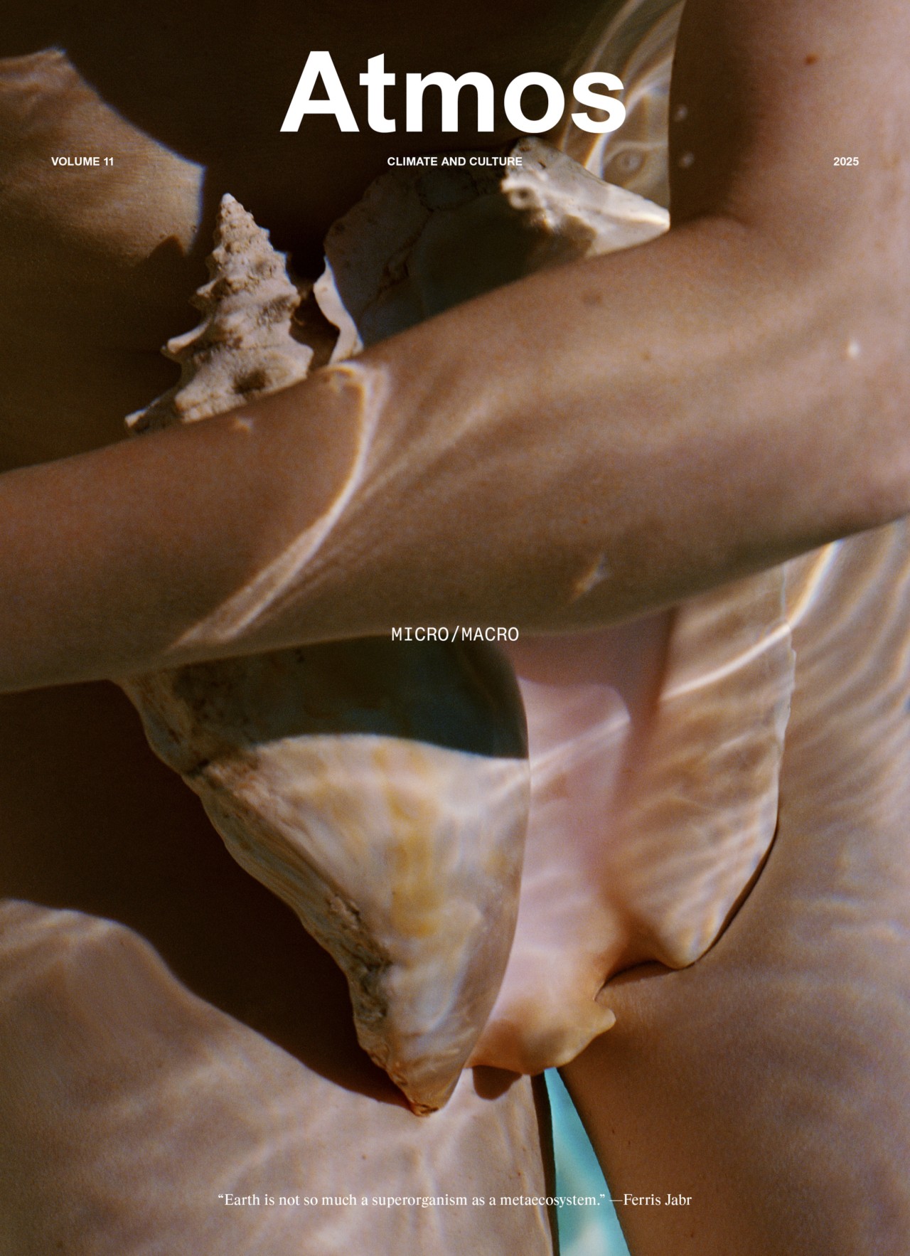 A person holds a large seashell against their bare torso underwater, with sunlight creating ripples and reflections. The cover text reads Atmos: Climate and Culture, Micro/Macro, Volume 11, 2023.