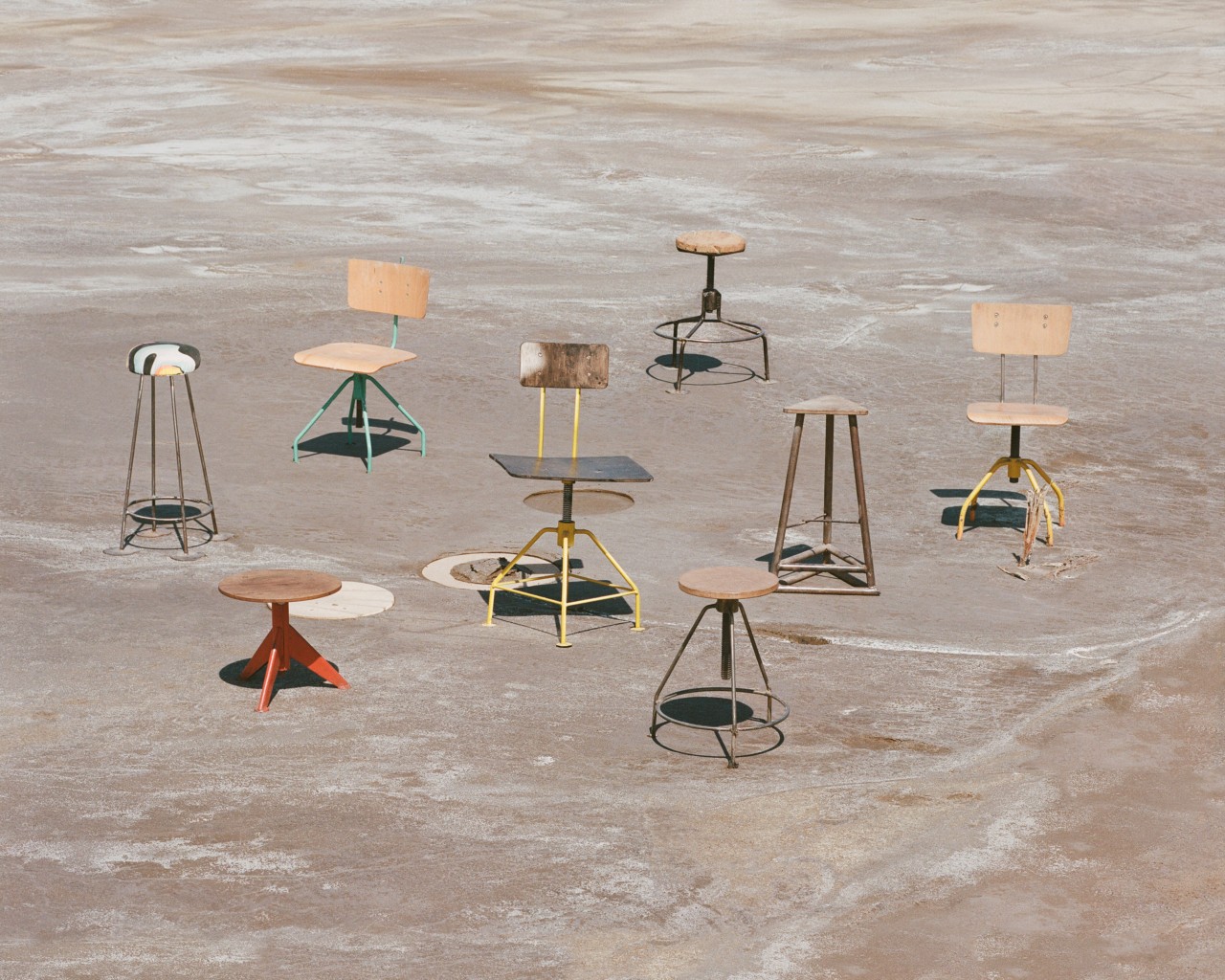 Several chairs sit on a cement surface.