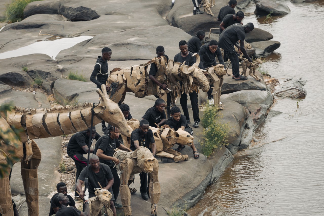 Several people carry animal puppets in the Congo Basin.