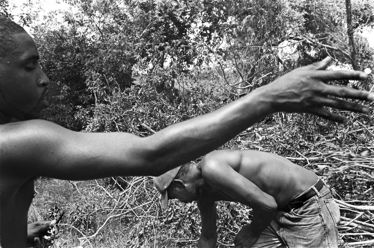 Williams' cousin Jason and Uncle Guillard working to clear their storm-ravaged backyard after Hurricane Katrina.