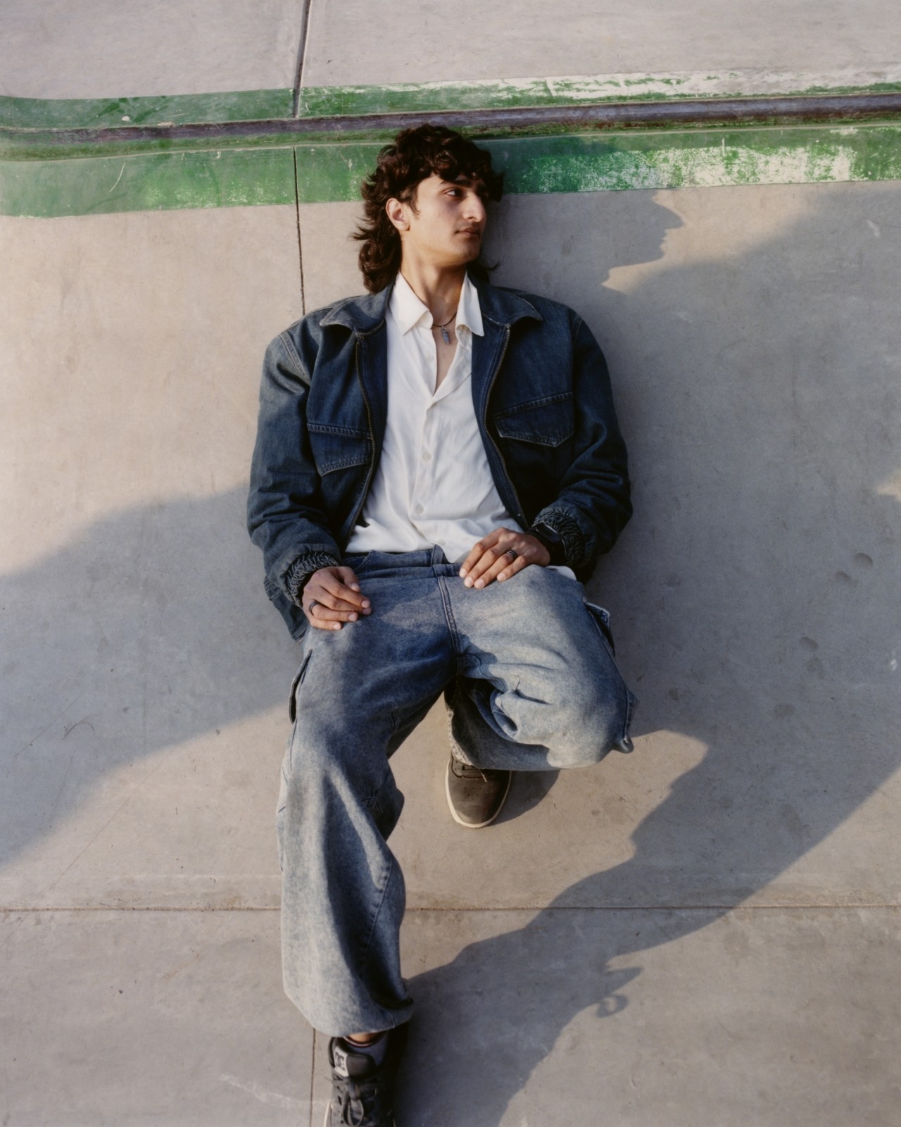 A Pakistani skater lays down in a skatepark.