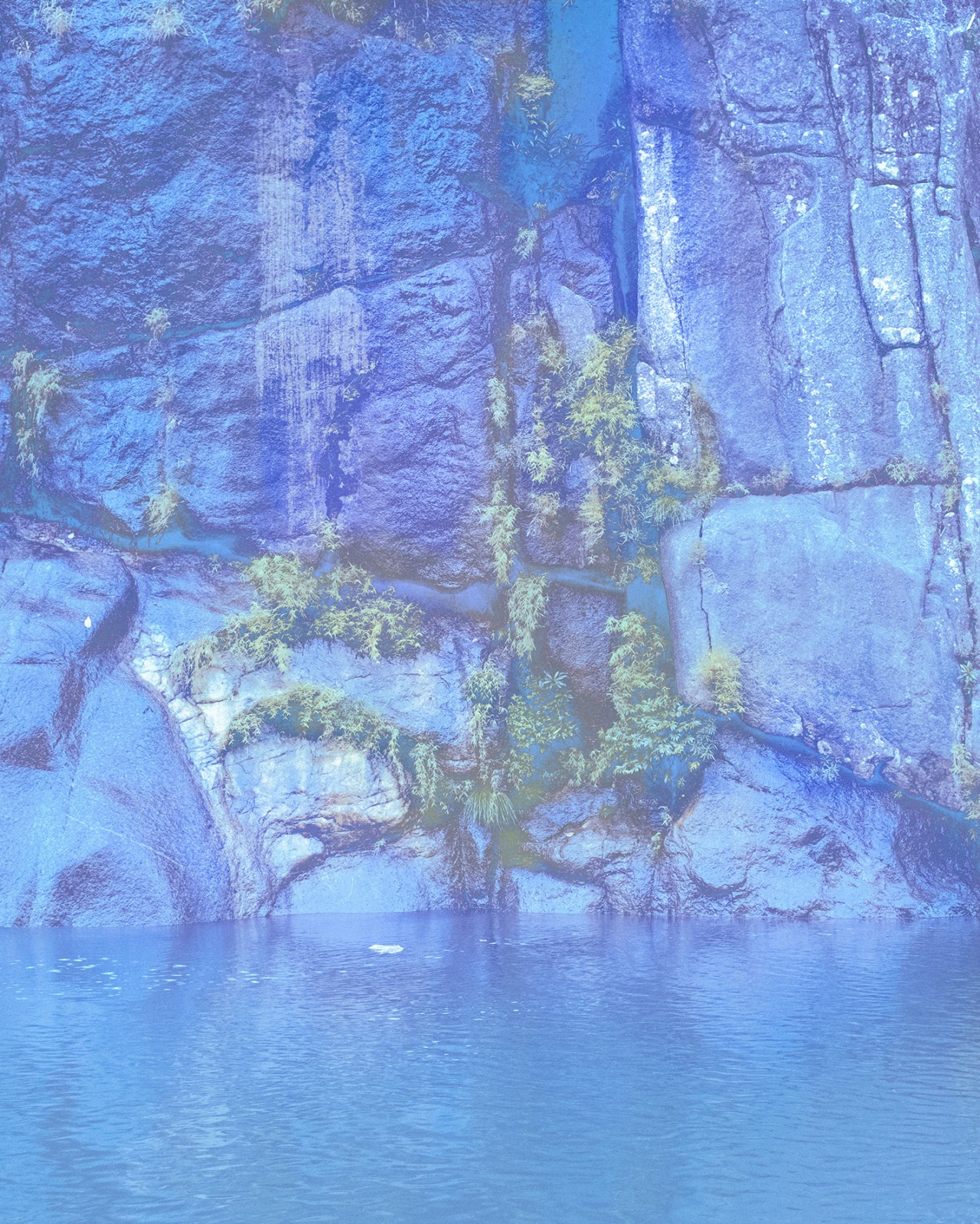 Water sits below a cliff.