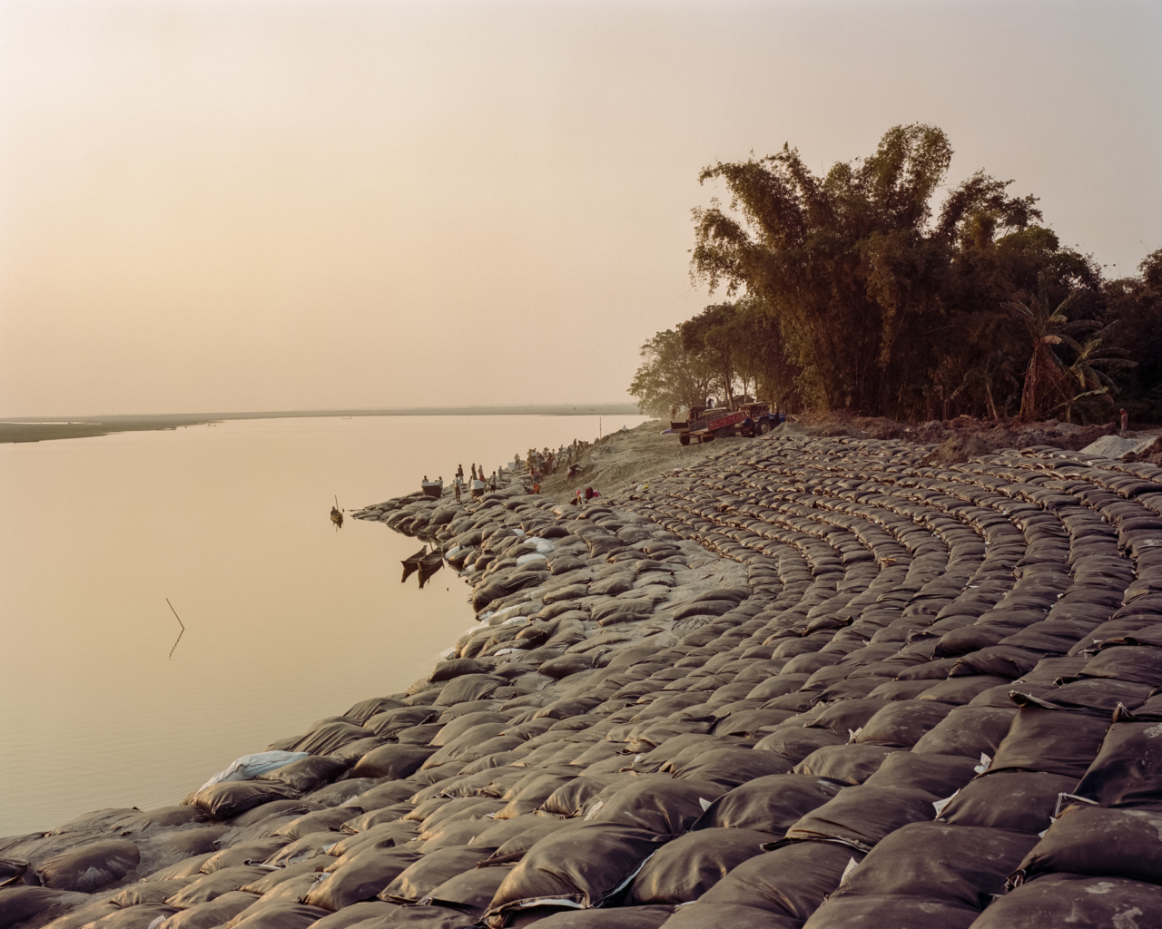 New sight of the riverbank. Workers filling up and placing huge geotextile sandbags in order to protect the bank of the island. More than 100 km of the riverbank surrounding Majuli has been covered by sandbags to avoid landslides on the bank.