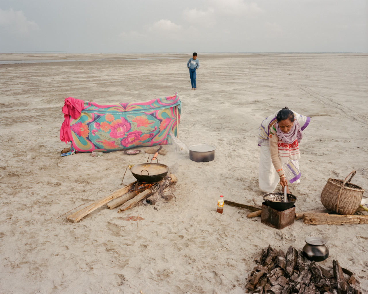Arima Das is cooking a festive lunch on a newly built sand island for his family and friends. After the morning fishing, they spend a full day together: praying for the abundance of fish to the gods of the river, eating rice, drinking tea and buffalo milk on the fine-grained sand in the Brahmaputra riverbed.