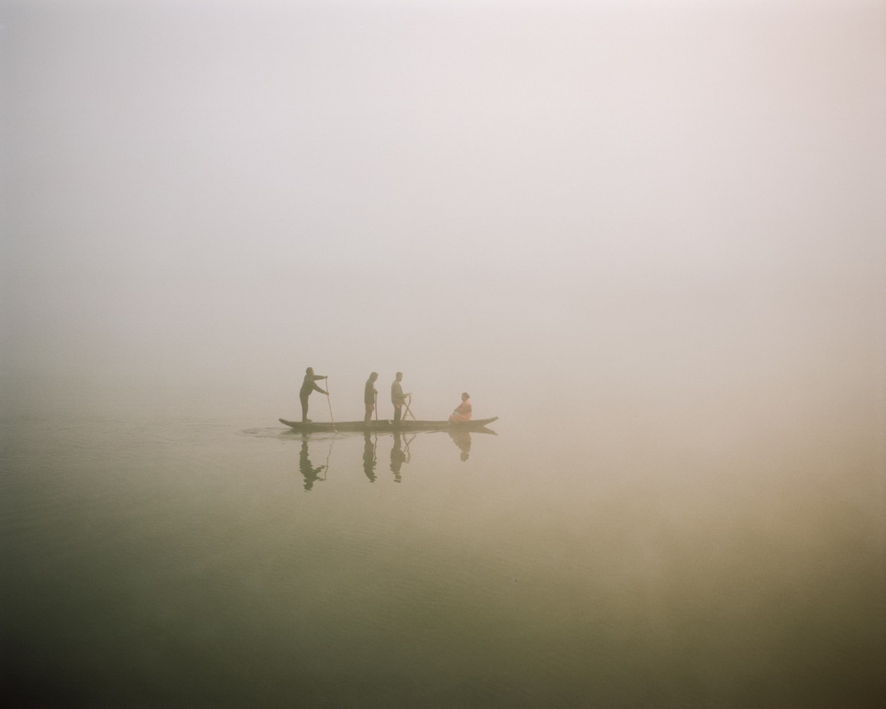 Four people sail along the river.