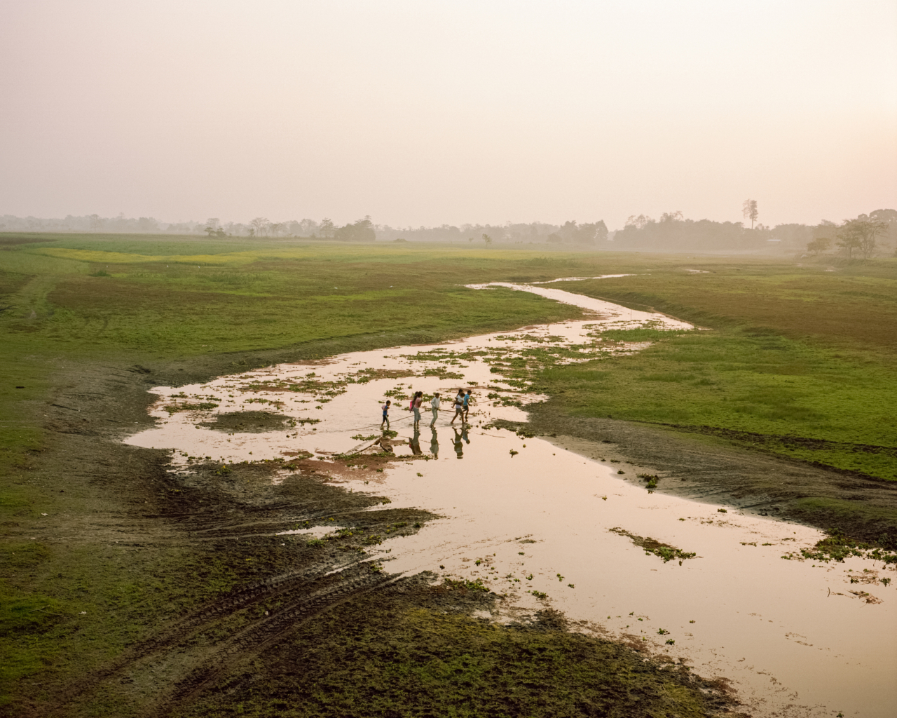 Four people cross the Brahmaputra river.